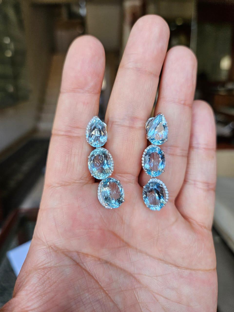 Bellissimi orecchini pendenti in stile moderno con acquamarina, oro bianco 18 carati e diamanti naturali. Il peso delle acquemarine è di 21.40 carati. Il peso dei diamanti è di 0,47 carati. Il peso netto dell'oro 18 carati è di 8,60 grammi. Il peso