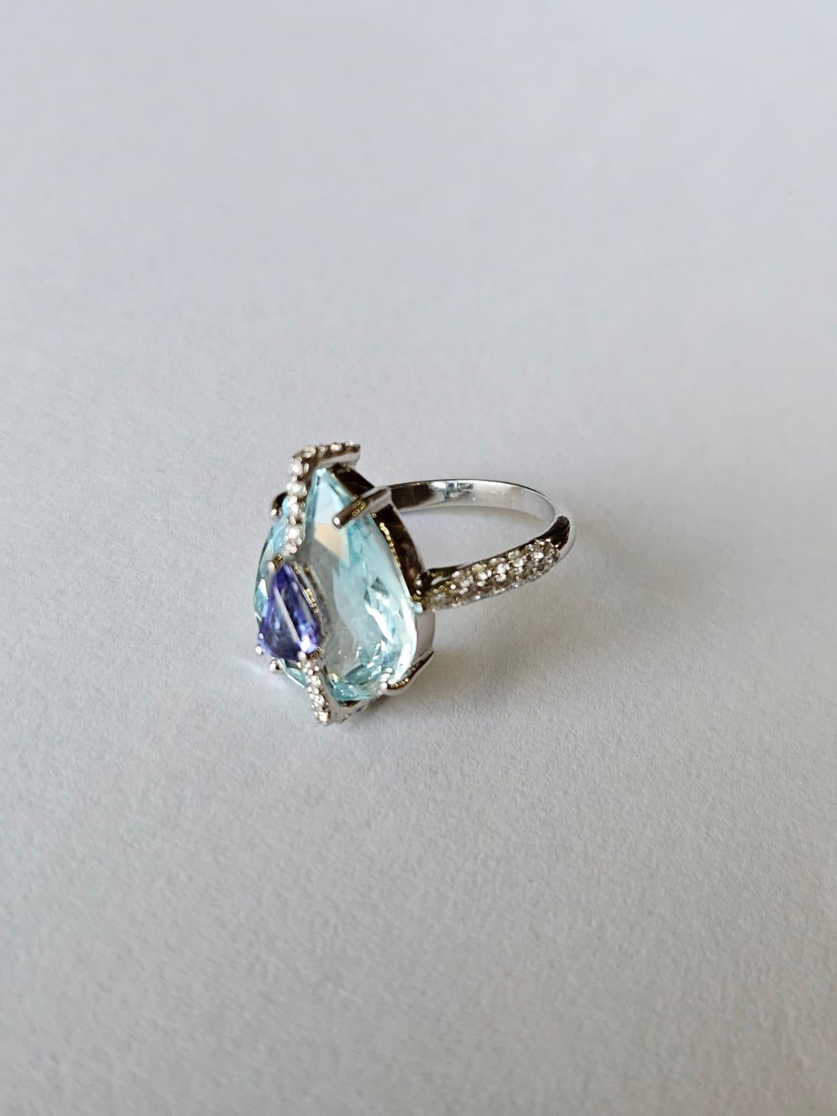 A very beautiful and gorgeous, modern style, Aquamarine & Tanzanite Cocktail /Engagement Ring set in 18K White Gold & Diamonds. The weight of the pear shaped Aquamarine is 5.61 carats. The weight of the Shield shaped Tanzanite is 0.38 carats. The