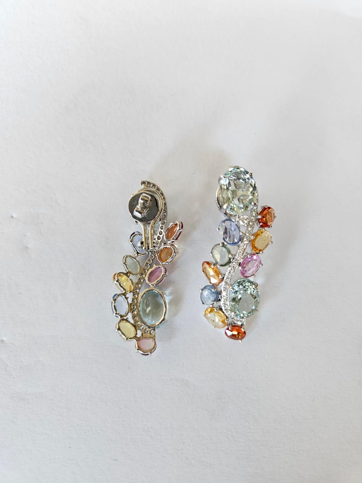 A very gorgeous and beautiful, modern style, Aquamarine & Multi Sapphires Chandelier Earrings set in 18K White Gold & natural Diamonds. The weight of the oval shaped Aquamarines is 13.50 carats. The weight of the Multi Sapphires is 9.91 carats. The