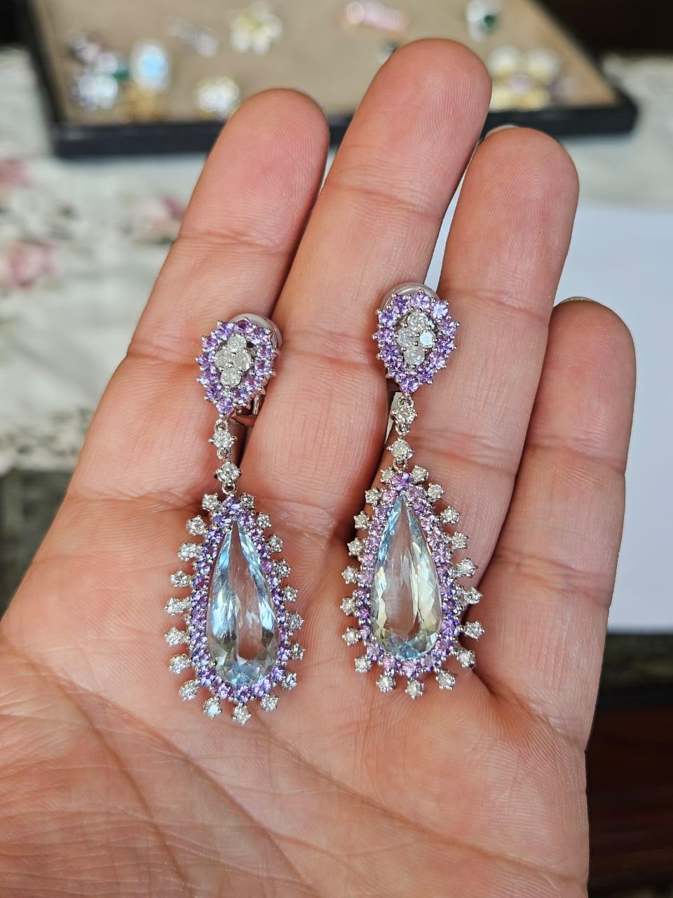 Splendidi e bellissimi orecchini pendenti in stile moderno con acquamarine e zaffiri viola, incastonati in oro bianco 18 carati e diamanti naturali. Il peso delle acquemarine è di 12.17 carati. Il peso degli zaffiri viola è di 4,56 carati. Il peso