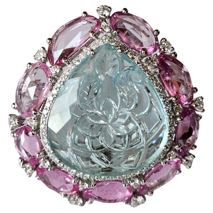 Un anillo de cóctel de aguamarina y zafiros rosas muy especial, único en su especie, para iniciar una conversación, engastado en oro blanco de 18 quilates y diamantes naturales. El peso de la aguamarina es de 10.98 quilates. La aguamarina se