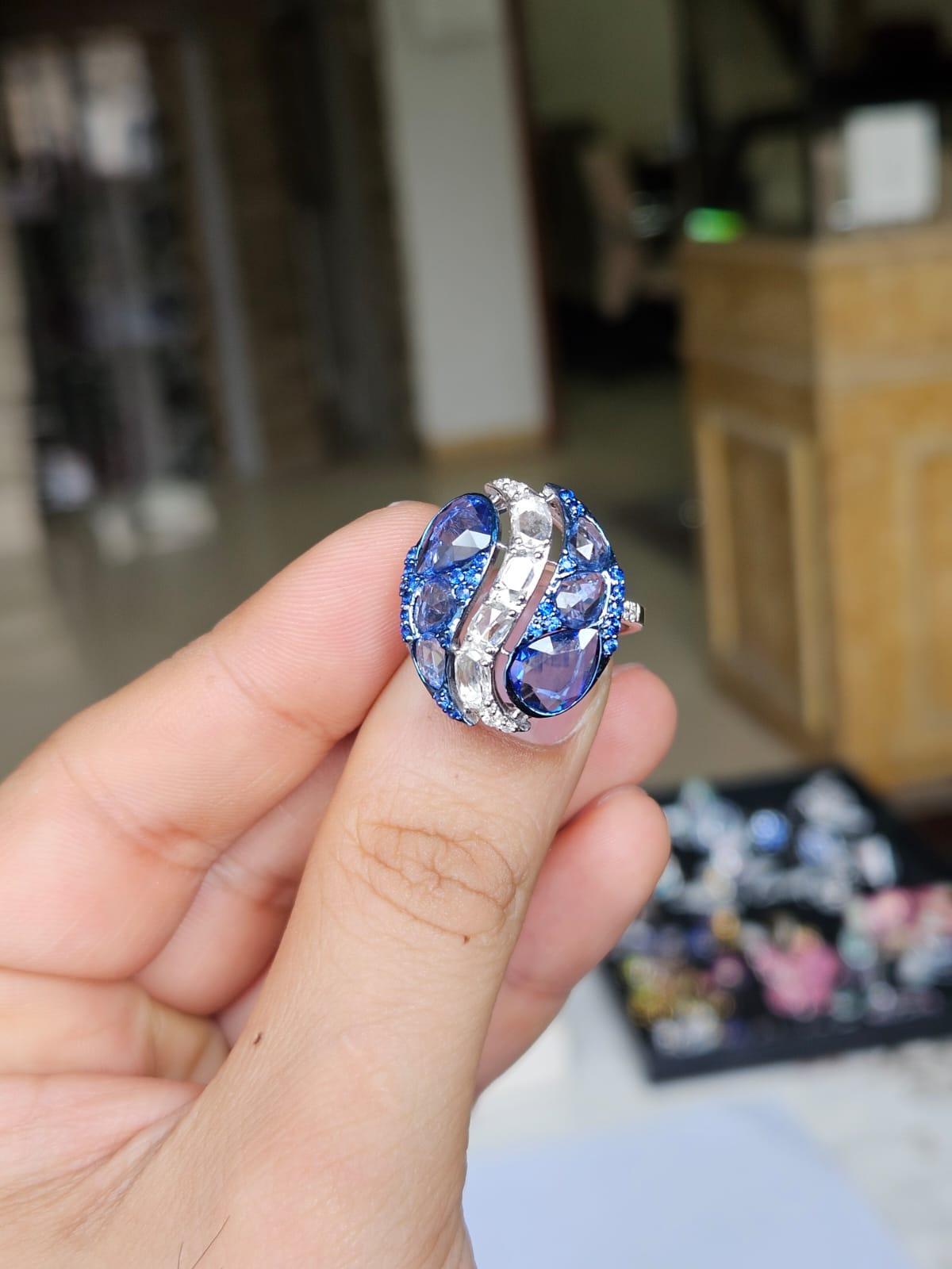 Un precioso anillo de cóctel de zafiros azules, de estilo moderno, engastado en oro blanco de 18 quilates y diamantes naturales. El peso de los zafiros azules es de 4.42 quilates. Los zafiros azules son de origen ceilanés (de Sri Lanka). El peso de