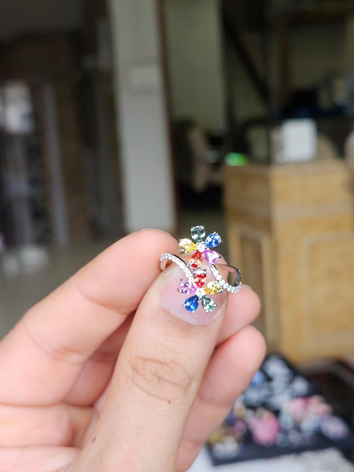 Un precioso y delicado anillo de compromiso de zafiros múltiples, de estilo moderno, engastado en oro blanco de 18 quilates y diamantes naturales. El peso de los Zafiros Múltiples es de 0.16 quilates. Los zafiros múltiples son de origen ceilanés