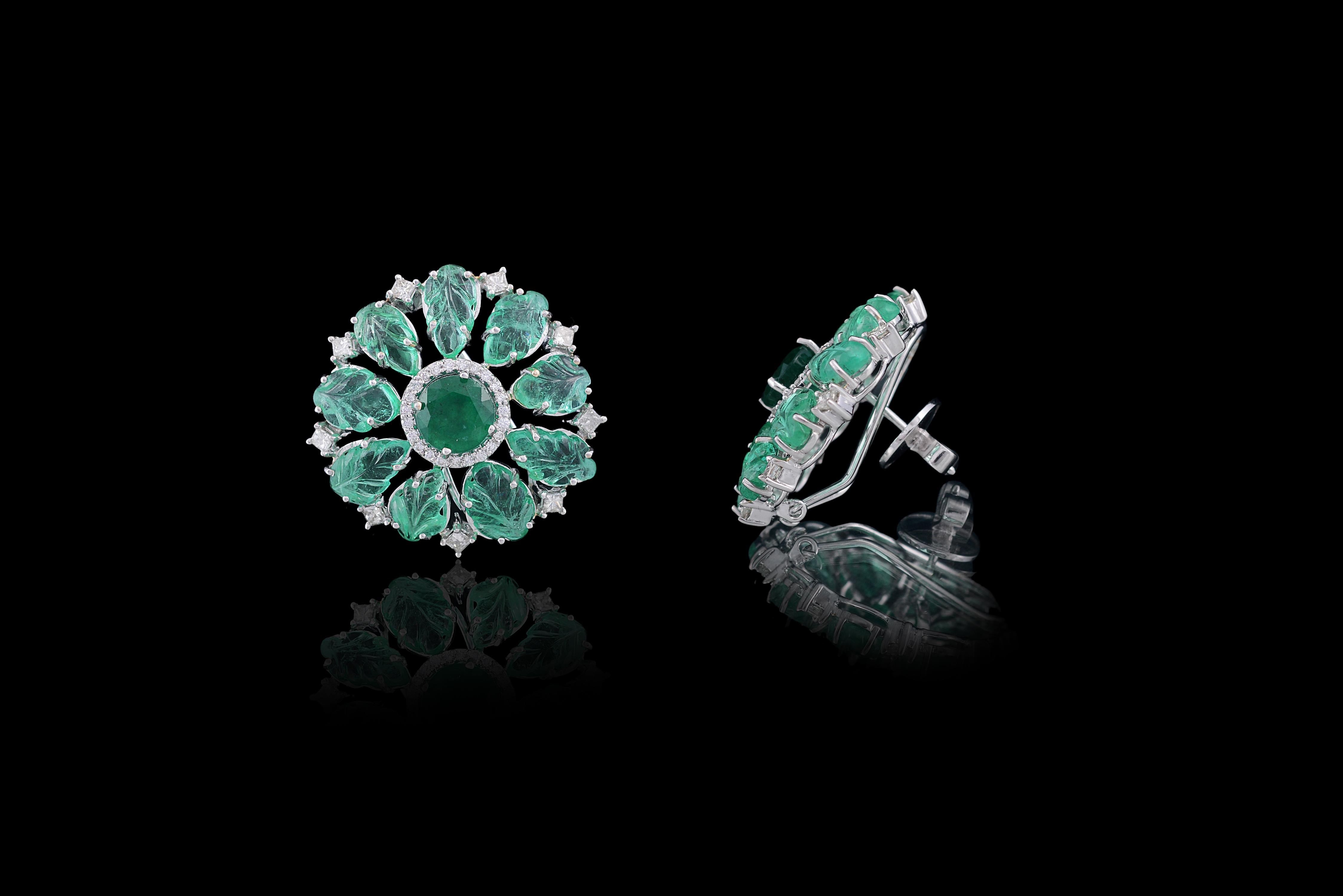 Gorgeous cut and carved emerald studs earring set in 18K white gold with diamonds. Both the leaves and the cut emerald are natural without any treatment. The emerald leaves weigh 11.32 carats whereas the cut weighs 3.2 carats. The diamond weight is