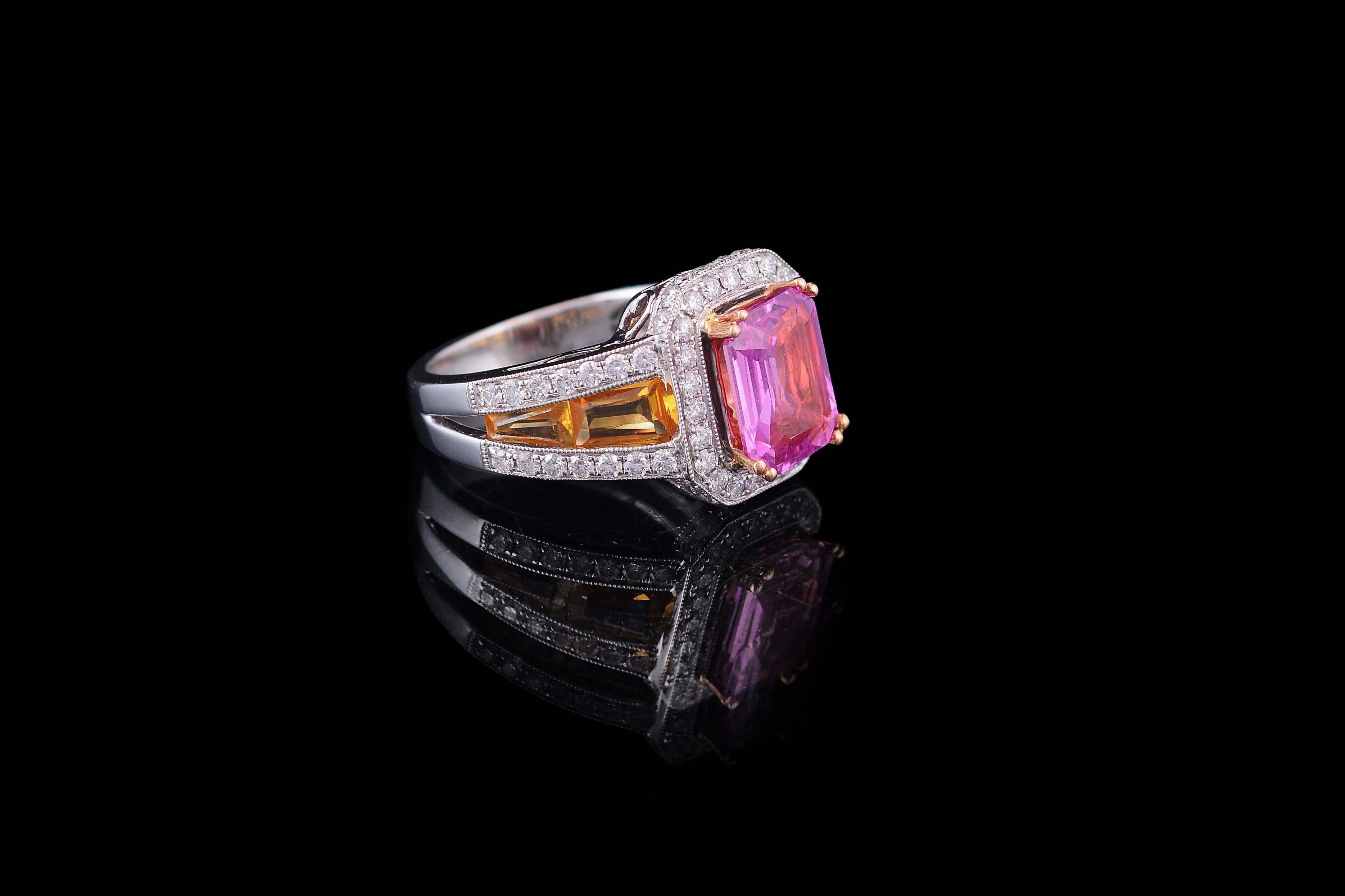 A classic GRS certified pink and yellow sapphire 3 stone ring with diamonds set in 18K gold. The certificate indicates that the pink sapphire in heated and originates from Madagascar. The weight of the pink sapphire is 2.75 carats, and yellow