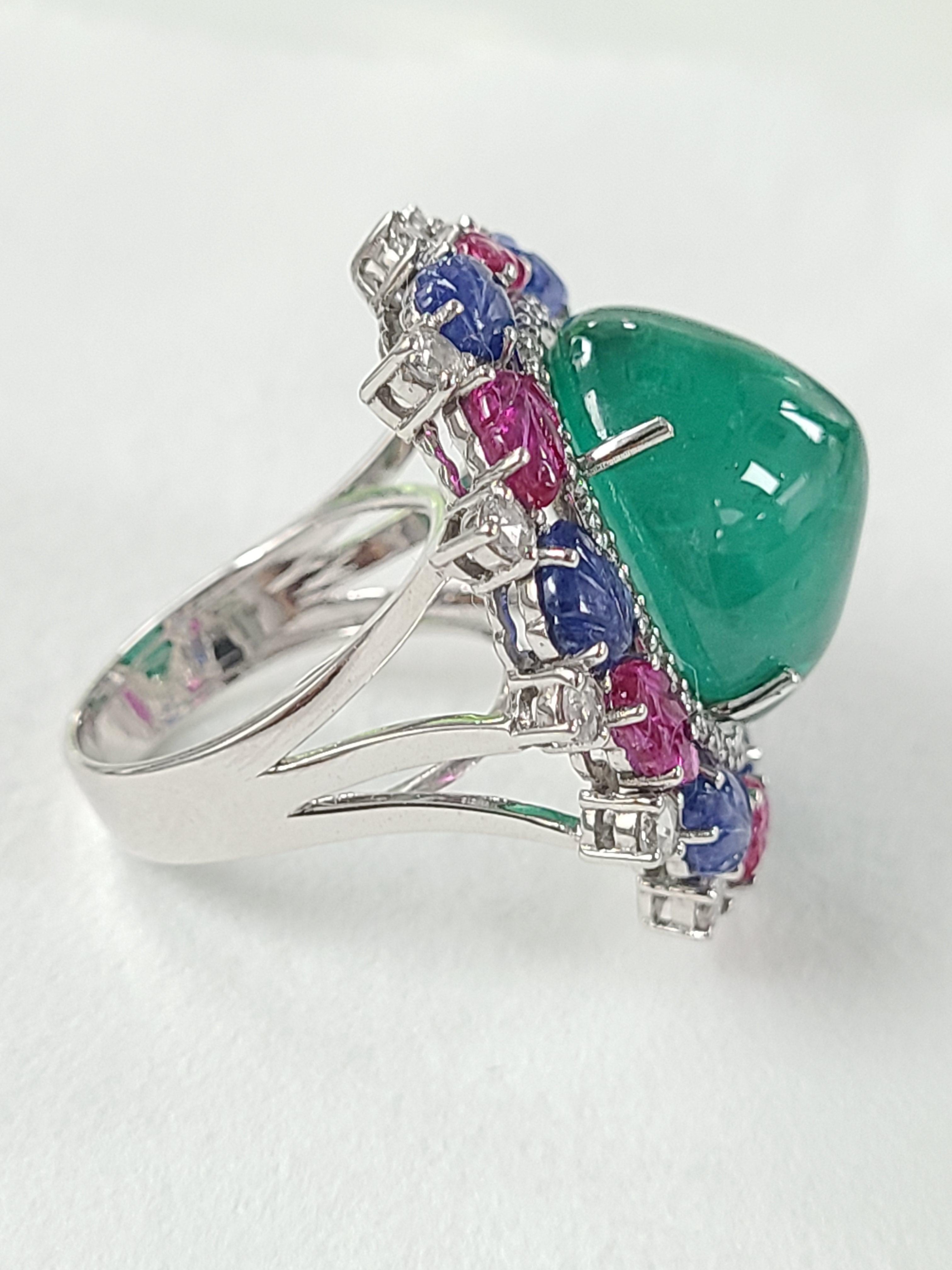 A gorgeous tutti frutti ring with natural emerald and natural un-heat carved blue sapphire and ruby leaves. The combined colorstone weight is 24.92 carats and diamond weight is .89 carats . Ring dimensions in cm 3 x 2.6 x 3.5 (L X W X H). Ring size