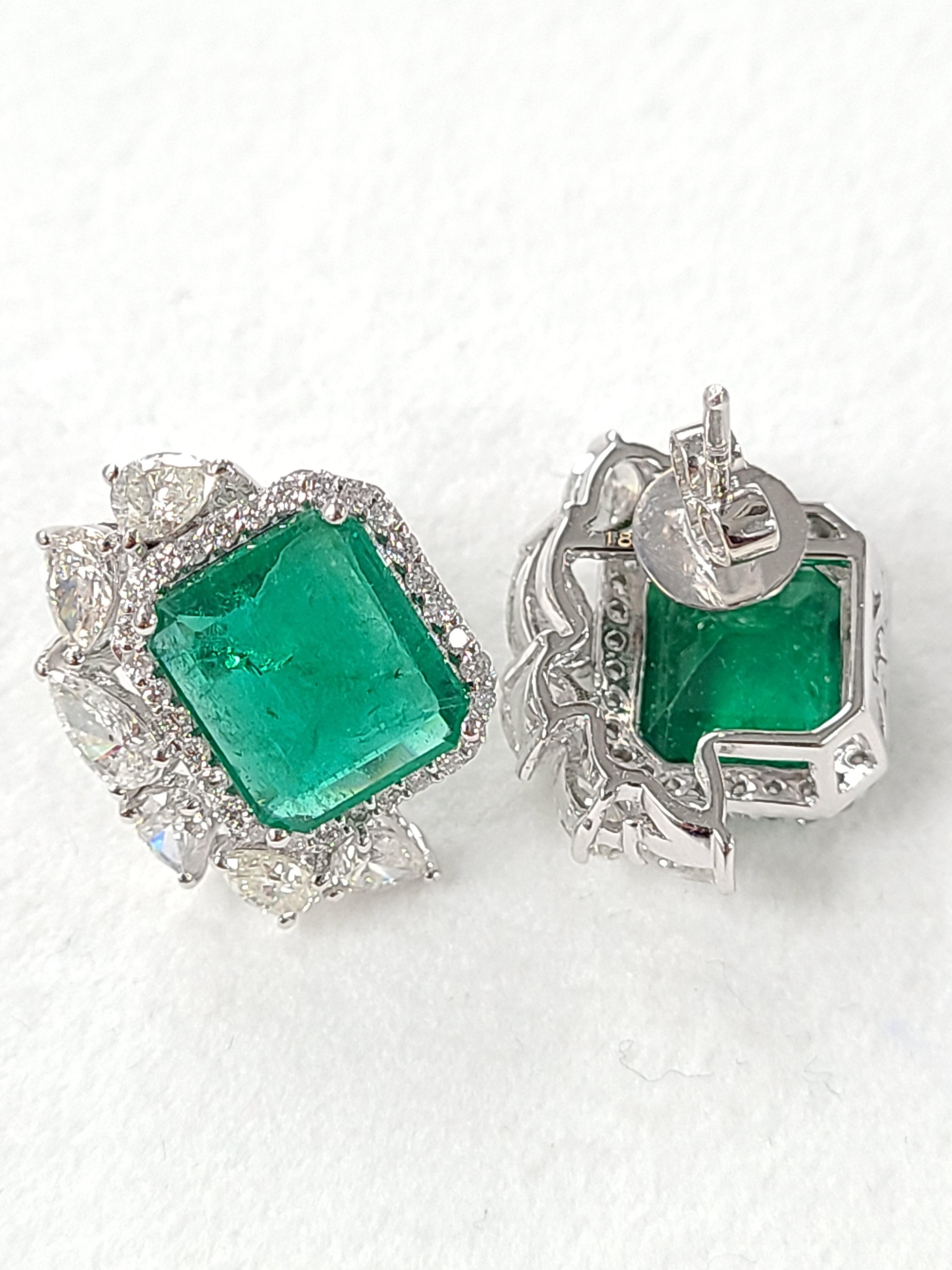 A pair of gorgeous emerald studs with a modern and chic design. these natural zambian emerald weight around 6.49 carat combined with diamond weight of 2.78 cts . these studs are perfect to wear for a elegant and modern look for a formal and semi