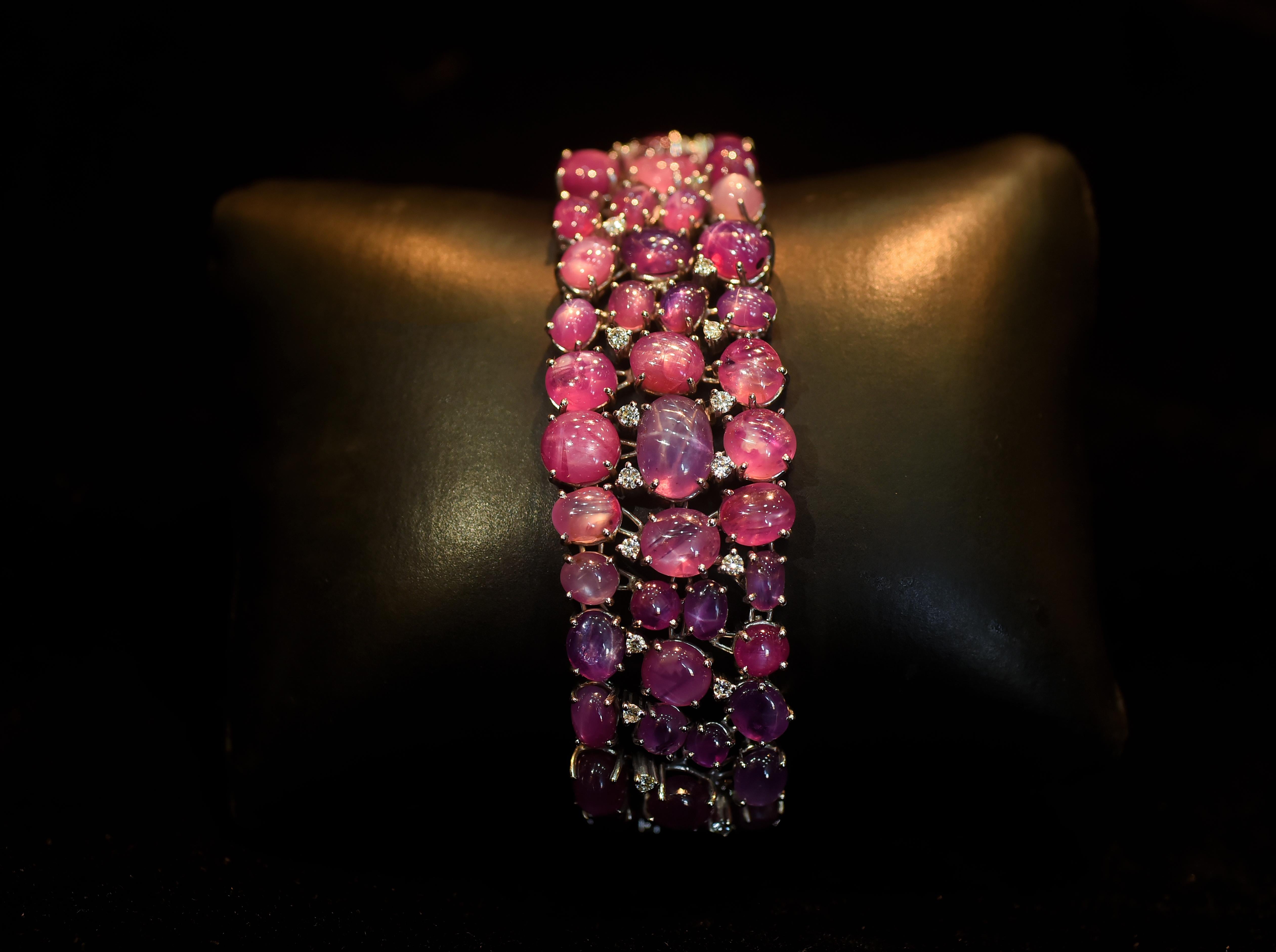 A gorgeous and one of a kind, Pink & Purple Star Ruby Bracelet set in 18K Gold & Diamonds. Star Ruby is a rare rarity of Ruby that exhibits a rare asterism (a six-rayed star) floating across the stone under specific lighting. The Star Ruby is