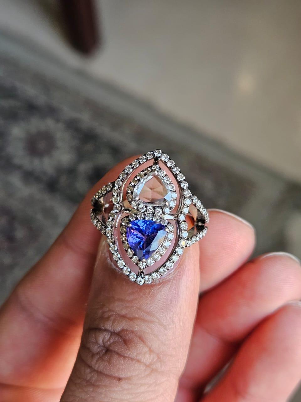 A very gorgeous and beautiful, Tanzanite Engagement Ring set in 18K White Gold & natural Diamonds. The weight of the Tanzanite trillion is 0.90 carats. The Tanzanite is responsibly sourced from Tanzania. The combined Diamonds weight is 1.44 carats.
