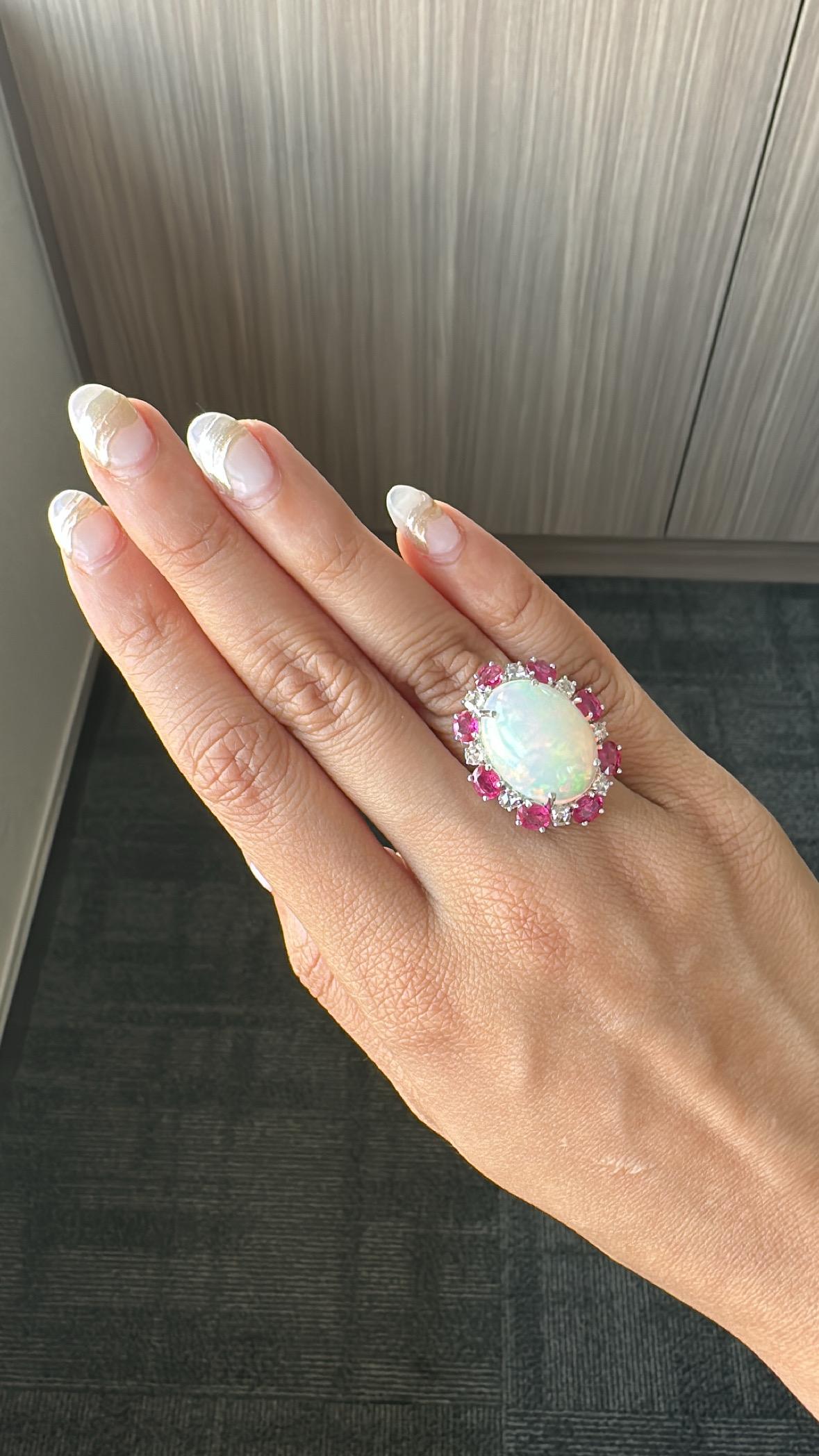 A very gorgeous and one a kind, Opal & Ruby Cocktail Ring set in 18K White Gold & Diamonds. The weight of the Opal is 11.57 carats. The Opal is of Ethiopian origin. The weight of the Rubies is 11.57 carats. The combined Diamonds weight is 0.70