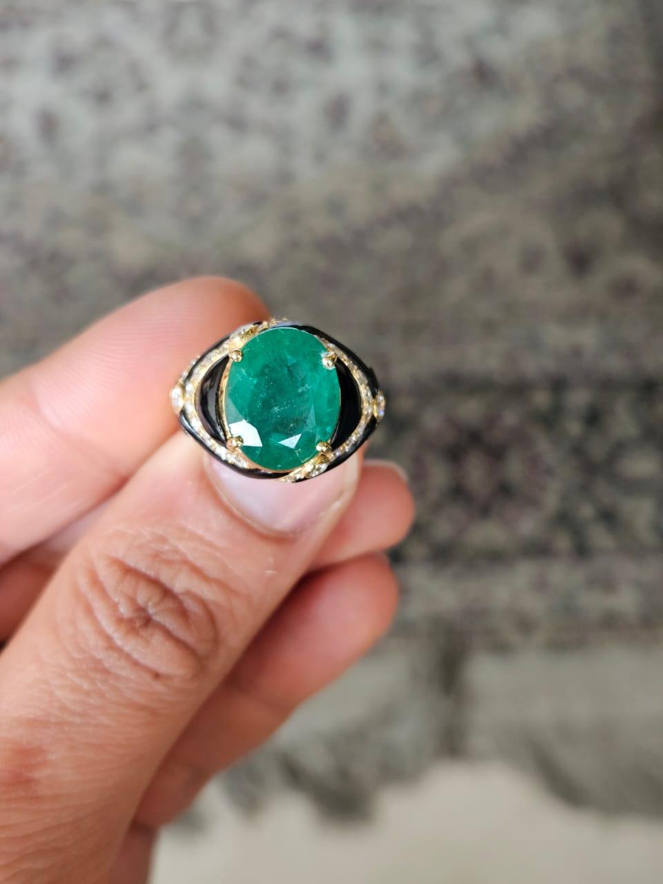 A very gorgeous and beautiful, Art Deco style, Emerald & Black Onyx Engagement Ring set in 18K Yellow Gold & natural Diamonds. The weight of the oval shaped Emerald is 6.54 carats. The Emerald is completely natural, without any treatment and is of