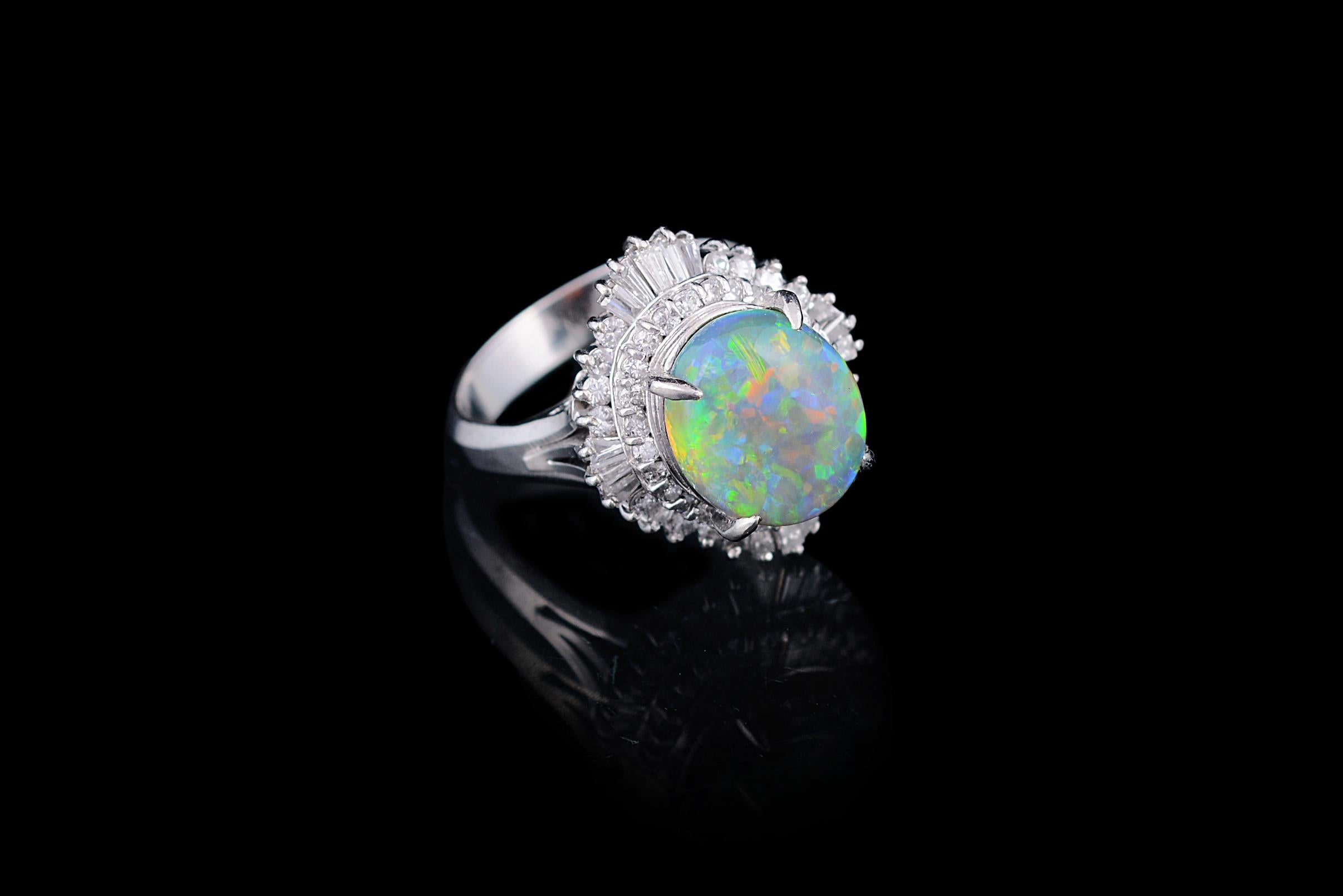 A very cute and dainty, Australian opal and taper baguette diamond cocktail ring set in Platinum 900. The opal is a natural Australian, weighing 4.31 carats. The opal has a green and orange play of colour. The combined weight of the diamonds is 0.97