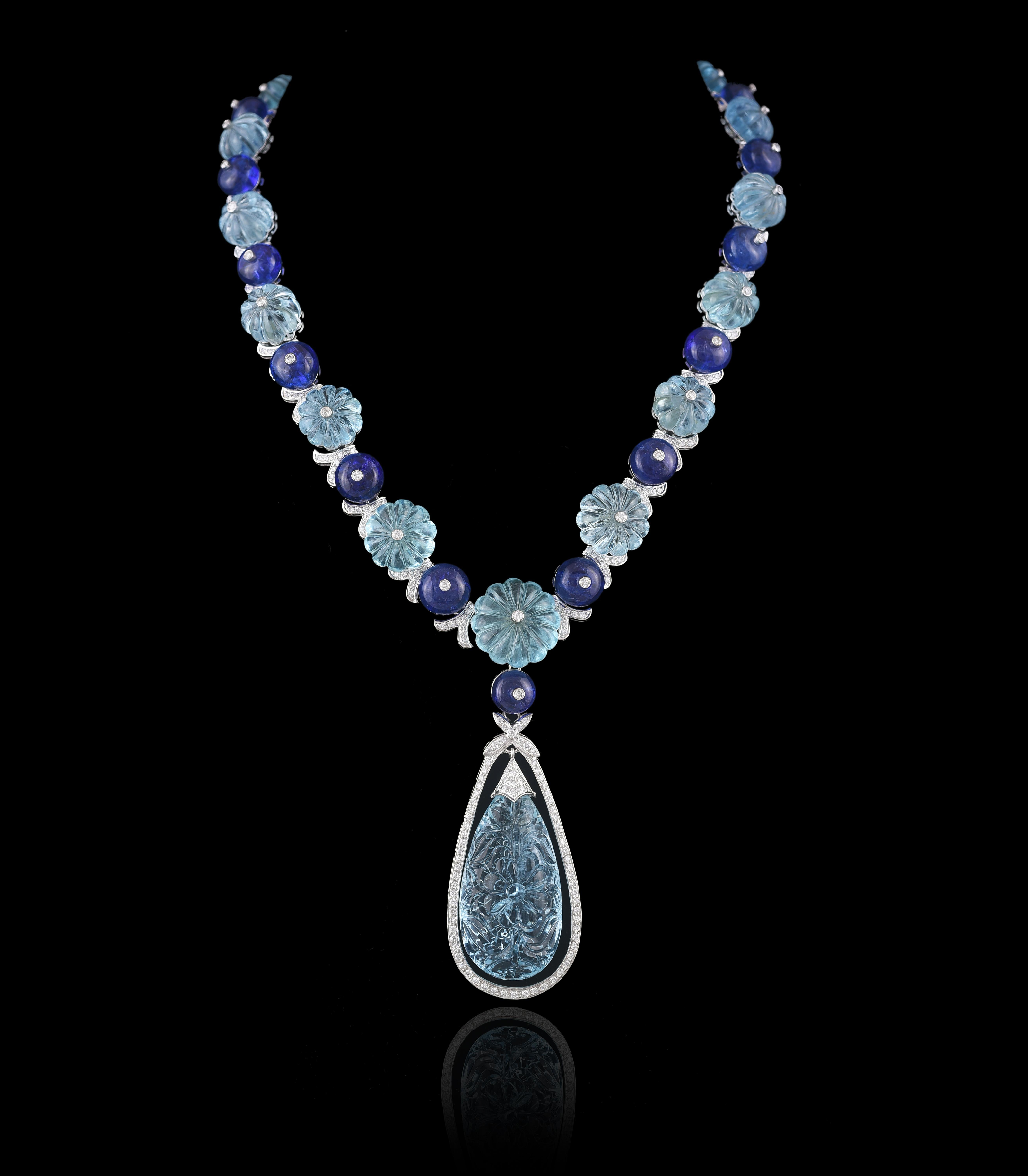 A stunning, one of a kind carved Aquamarine, Tanzanite Beads & Diamonds Necklace Set in 18K gold. The Set consists of a necklace and a matching pair of Earrings. The Aquamarine is hand- carved in our own workshop, and completely natural without any