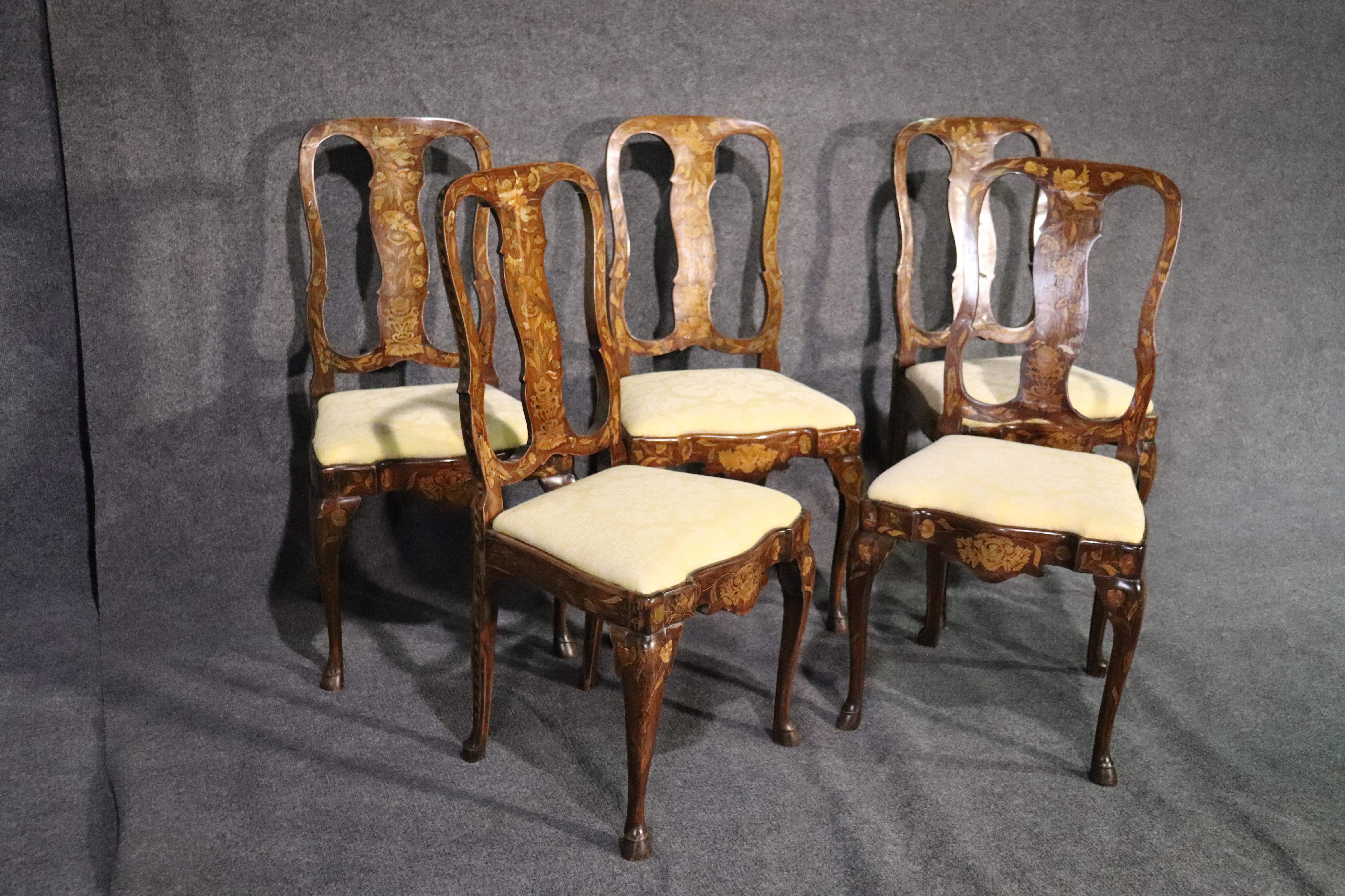 This is a rare and unique set of Dutch-made inlaid dining chairs. The chairs are from the 1890s era and will show small losses of inlay here and there but are essentially in good condition and have clean upholstery. The cushions are drop in cushions