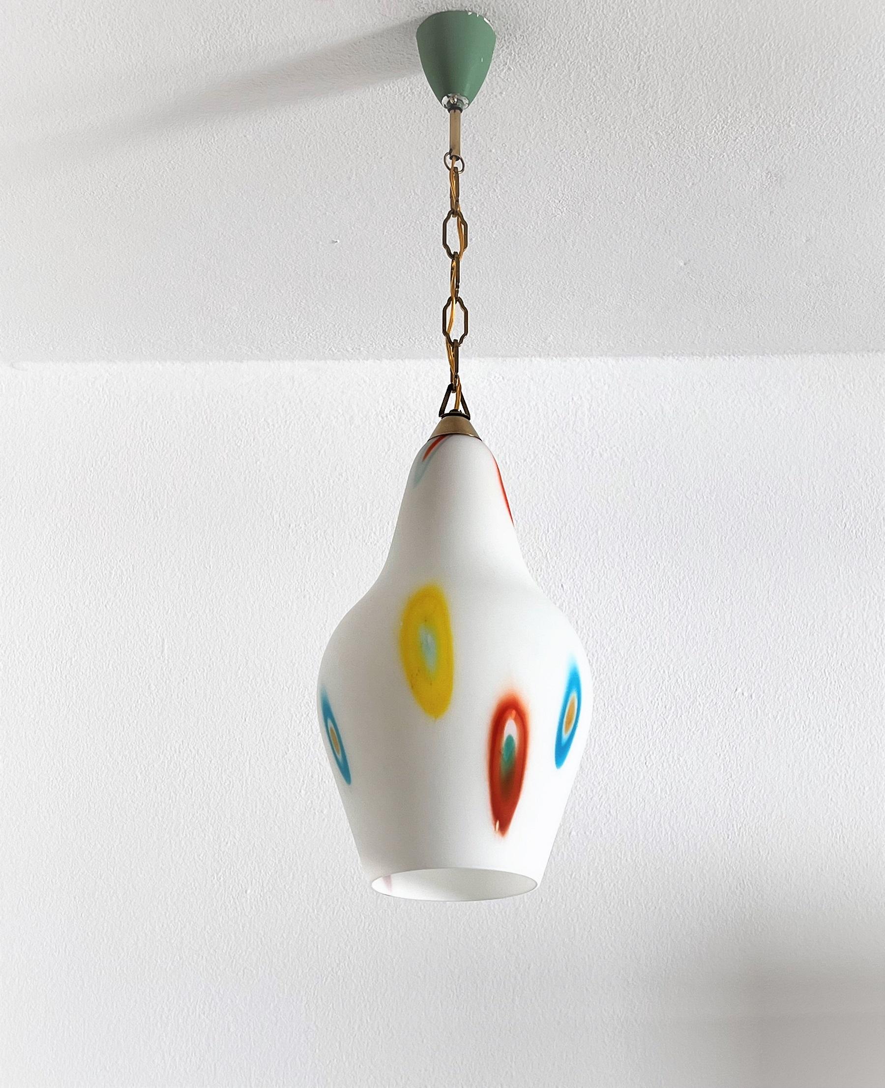 Beautiful set of two glass pendant lamps made in Italy, in the 1970s.
The colorful funny pendants are made of white Murano glass with colorful Murrine glass pieces scattered across the lamp.
They are equipped with their original brass chains and