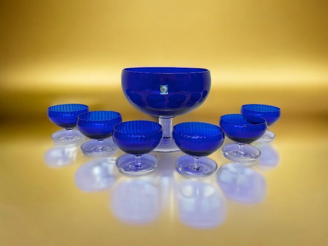 Add a touch of opulence to your home or dining table with this charming set of 6 fruit bowls / sherbet cups and a large serving bowl. Perfect hand blown cobalt blue and clear Murano glass to enhance any chic or eclectic home. We would like to see it