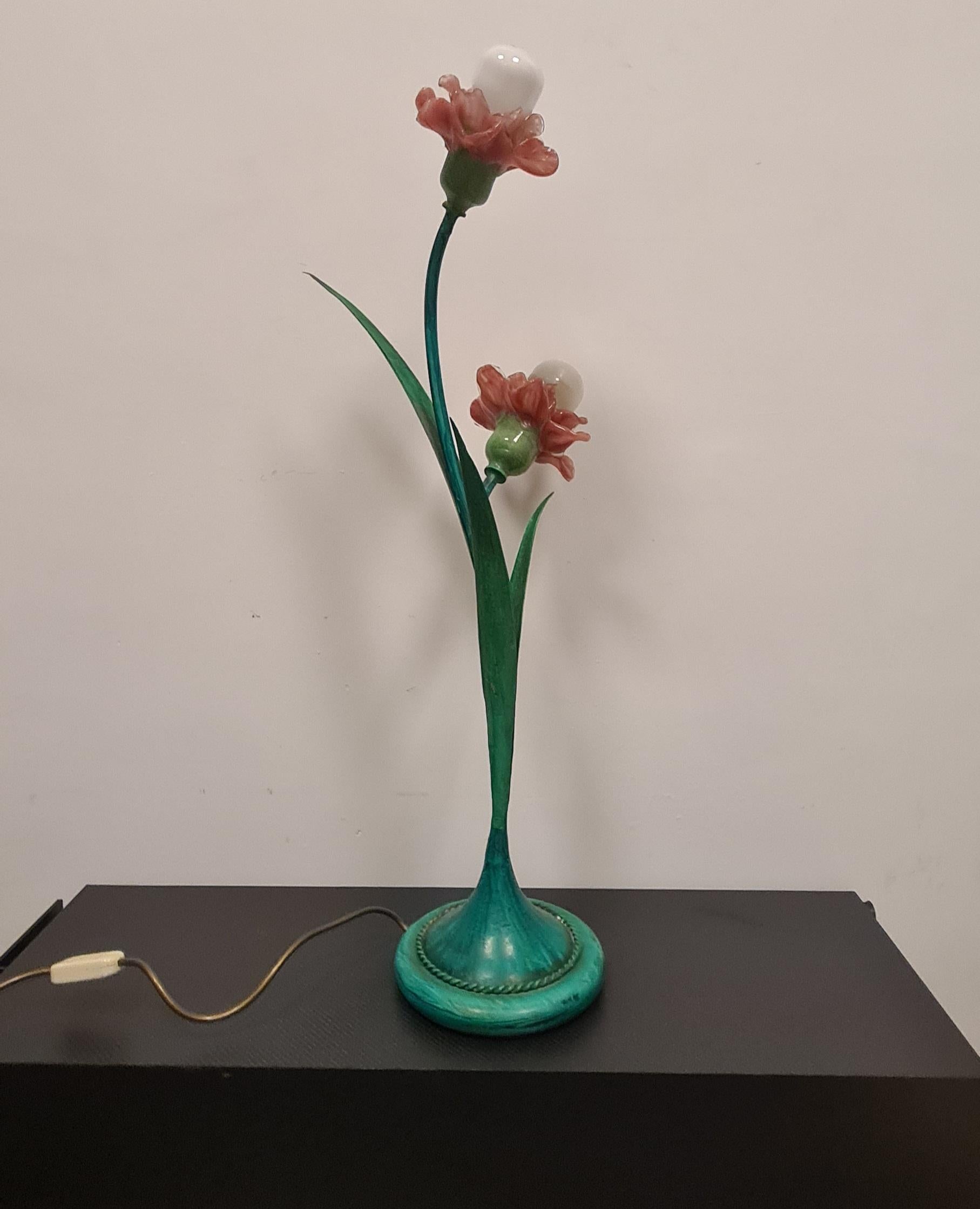 Set of lacquered wrought iron lamps and murano glass flower lampholders.

The set consists of a refined table lamp and a matching wall sconce.

The table lamp features a green lacquered wrought iron body and two pink murano glass flower-shaped lamp