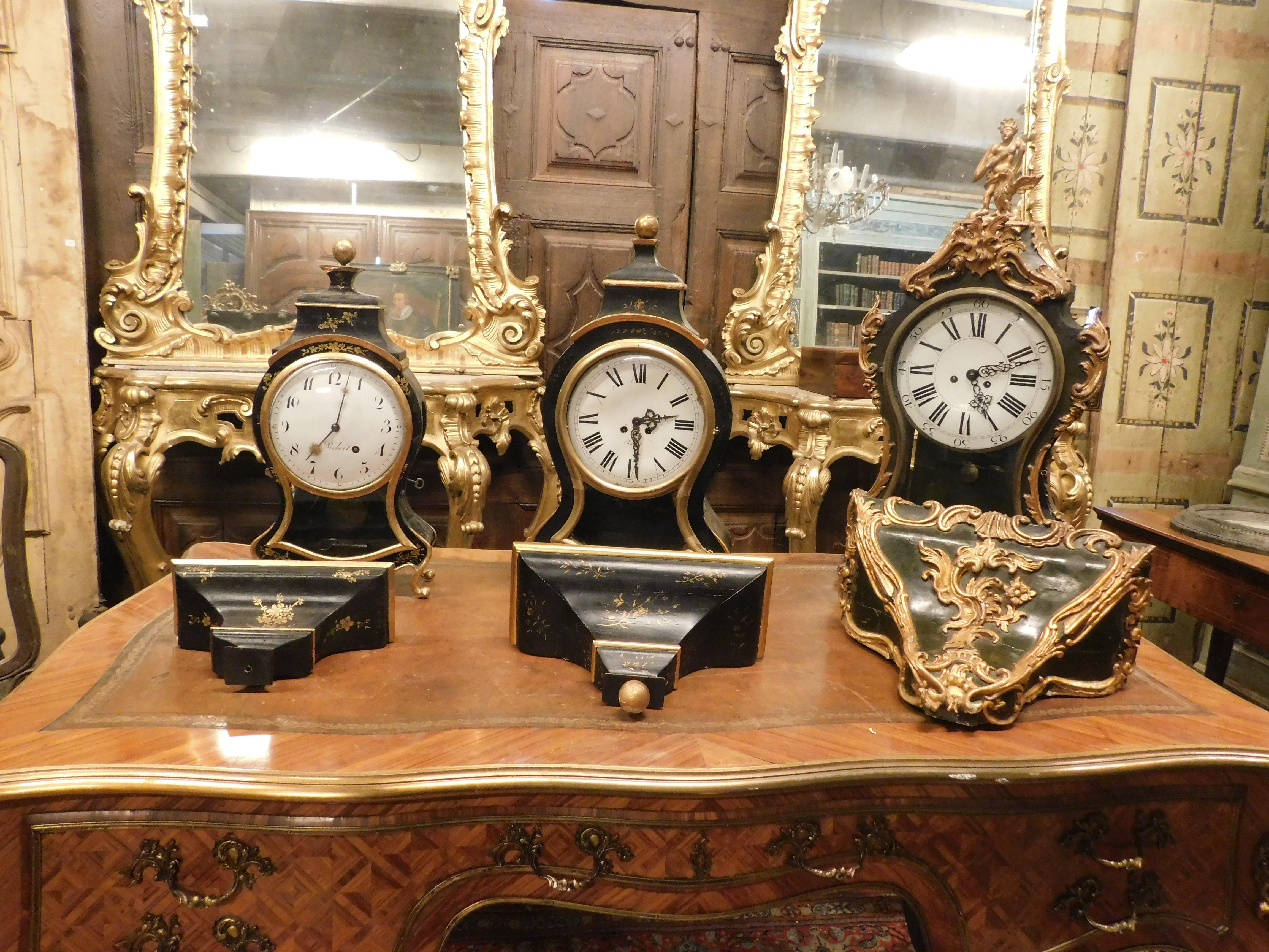 lote de 3 relojes en madera ebonizada con perfiles y pies decorados a mano con motivos vegetales dorados, del siglo XIX, dos de tres con la firma 