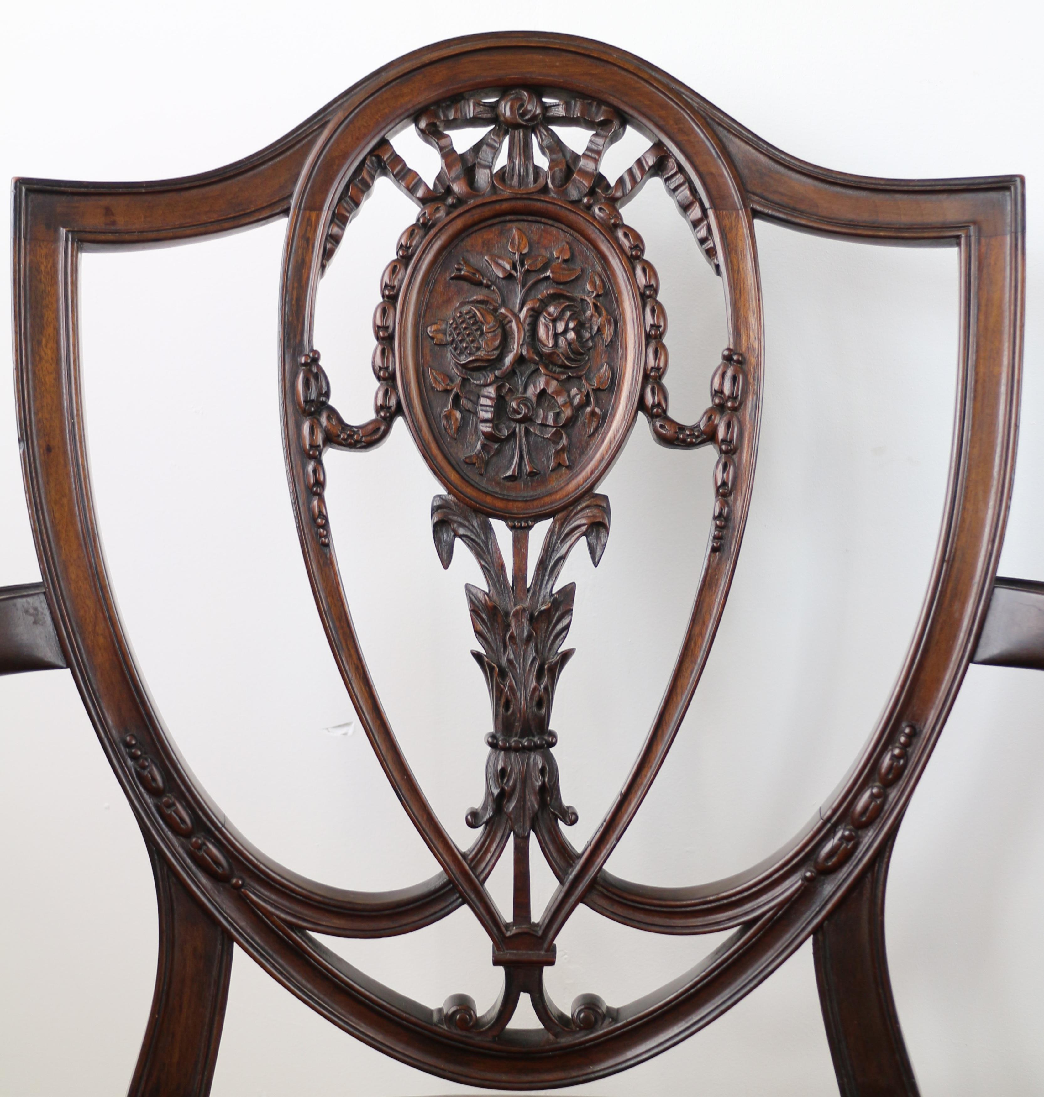 A beautiful set of ten Victorian mahogany cabriole carver arm chairs from a 1788 Georgian Hepplewhite design and probably made by Gillows. Featuring broad serpentine shaped sprung seats each chair has a pierced shield shaped back carved with ribbon