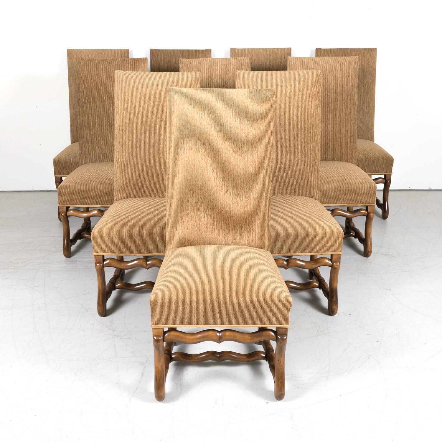 An elegant set of 10 French Louis XIII style os de mouton dining side chairs, having beautifully carved walnut frames with high rectangular backs and supported on os de mouton or sheep bone legs with stretcher, circa 1920s. These large and