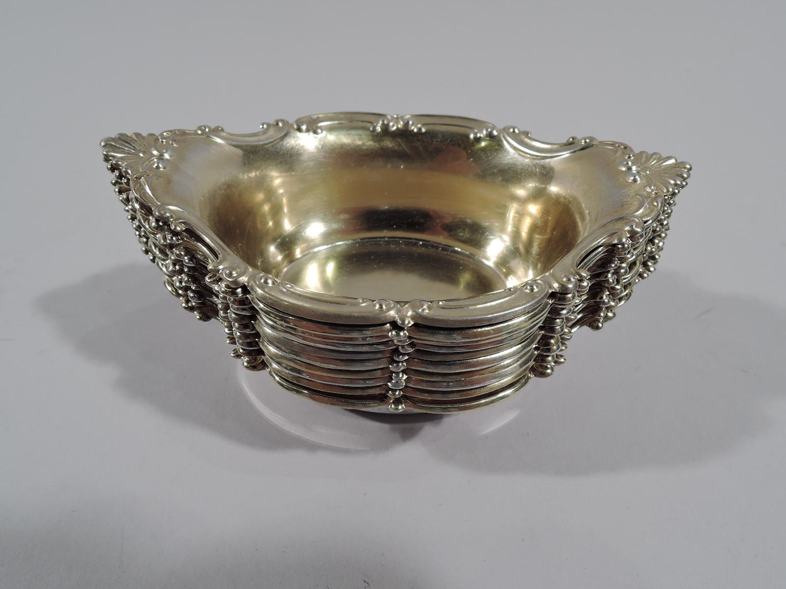Set of 10 turn-of-the-century Edwardian sterling silver nut dishes. Made by Gorham in Providence. Each: Oval bowl with c-scroll rim and scallop shell ends. Interior gilt-washed. Fully marked and numbered A2433. Total weight: 8 troy ounces.