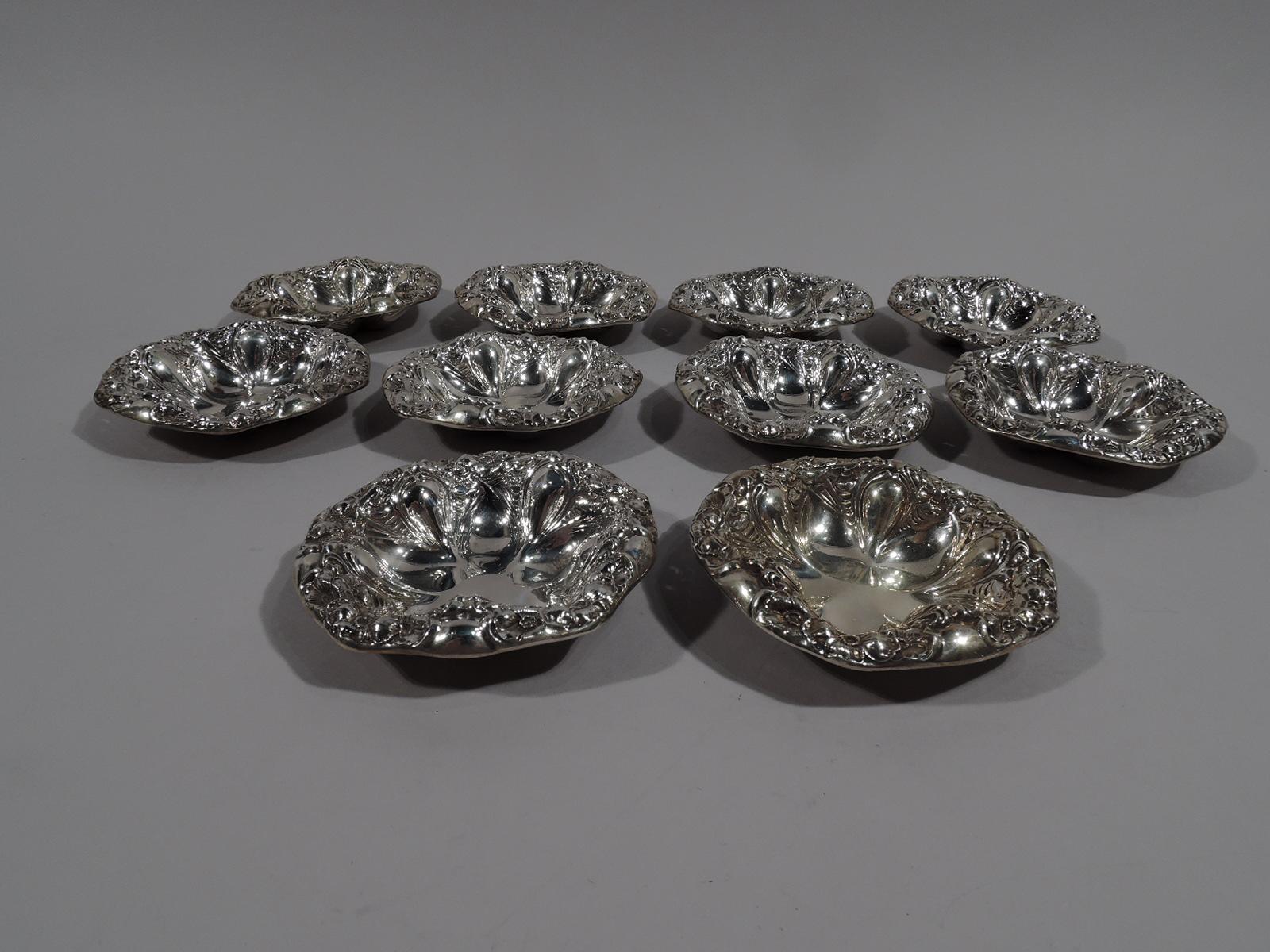 Set of 10 turn-of-the-century Art Nouveau sterling silver nut dishes. Made by Unger Brothers in Newark. Each: Shaped and plain well with alternating petals and lobes, and wavy rim. Dense repousse flower heads. Fully marked. Total weight: 6 troy