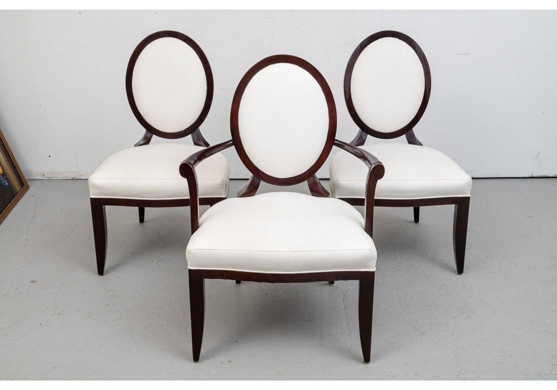 Barbara Barry’s signature Chair Design. The set consists of two arm and eight side chairs, in her iconic dark finish. Squared frames with X supports on back of the oval backs with curved supports attached to the seats. With tapering square curved