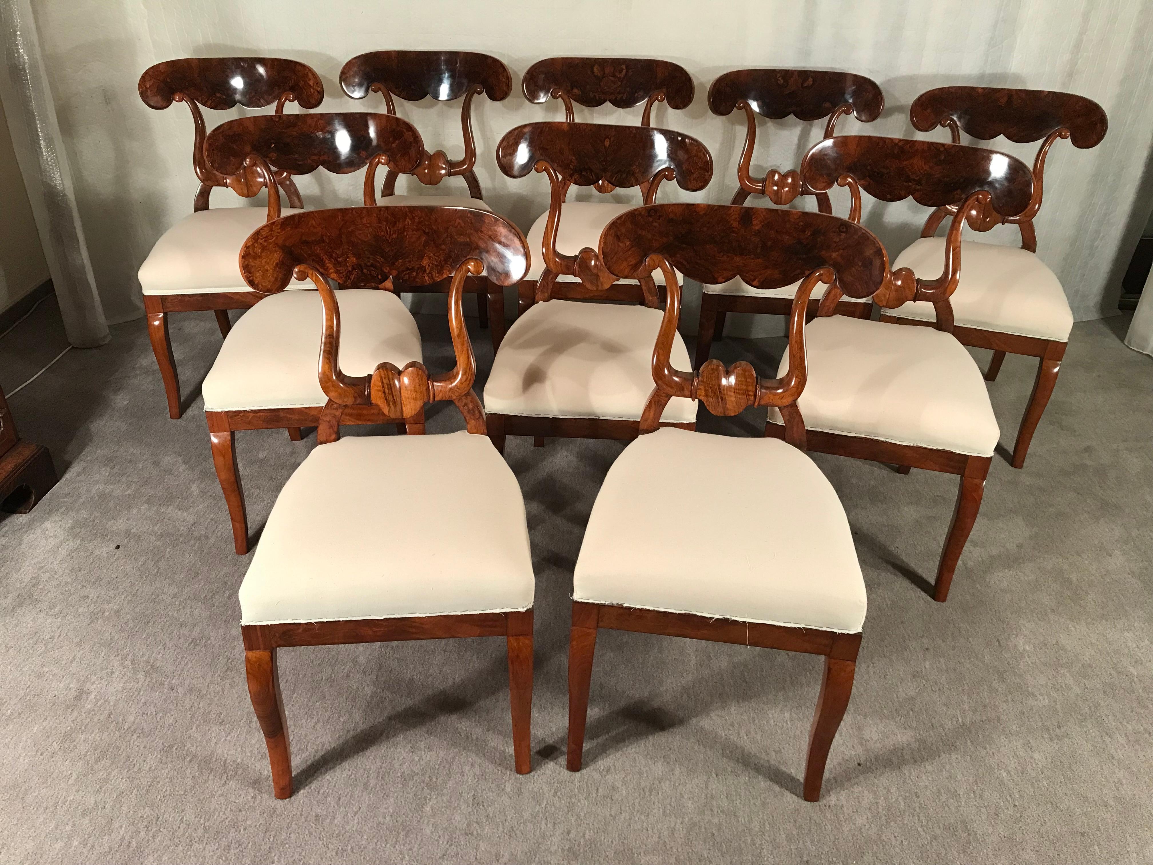 This exquisite set of 10 original Biedermeier chairs is a rare find. 
The so called original Biedermeier Ochsenkopf-Stuehle (ox-head chairs) get their name from their beautifully designed back. They date back to around 1820-30 and come from Southern
