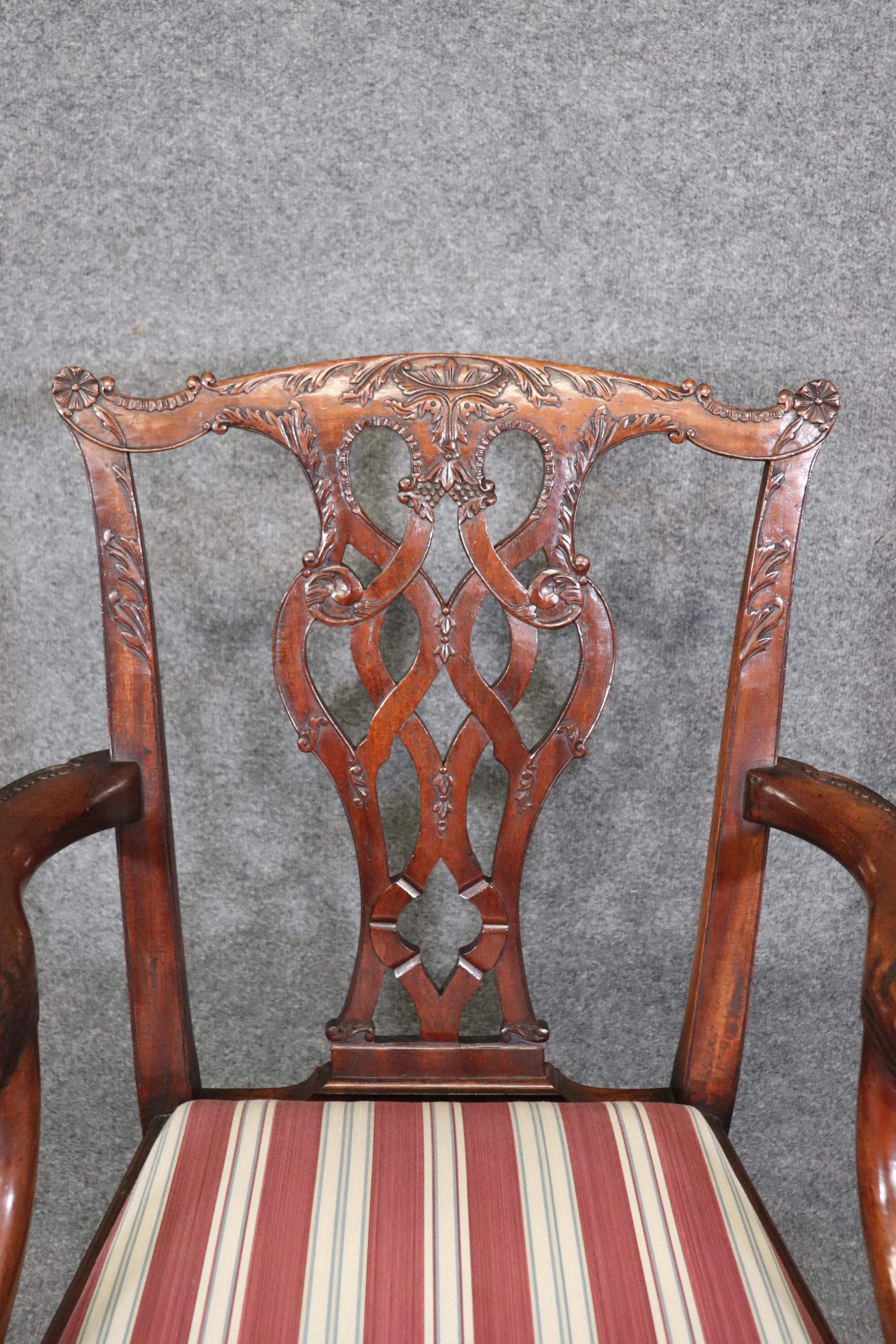 This is a gorgeous set of solid mahogany carved Chippendale style dining chairs. They feature beautiful acanthis carving and ball and claw feet as well as a pair of armchairs with dragon faced terminals at the end of the arms. They are in good