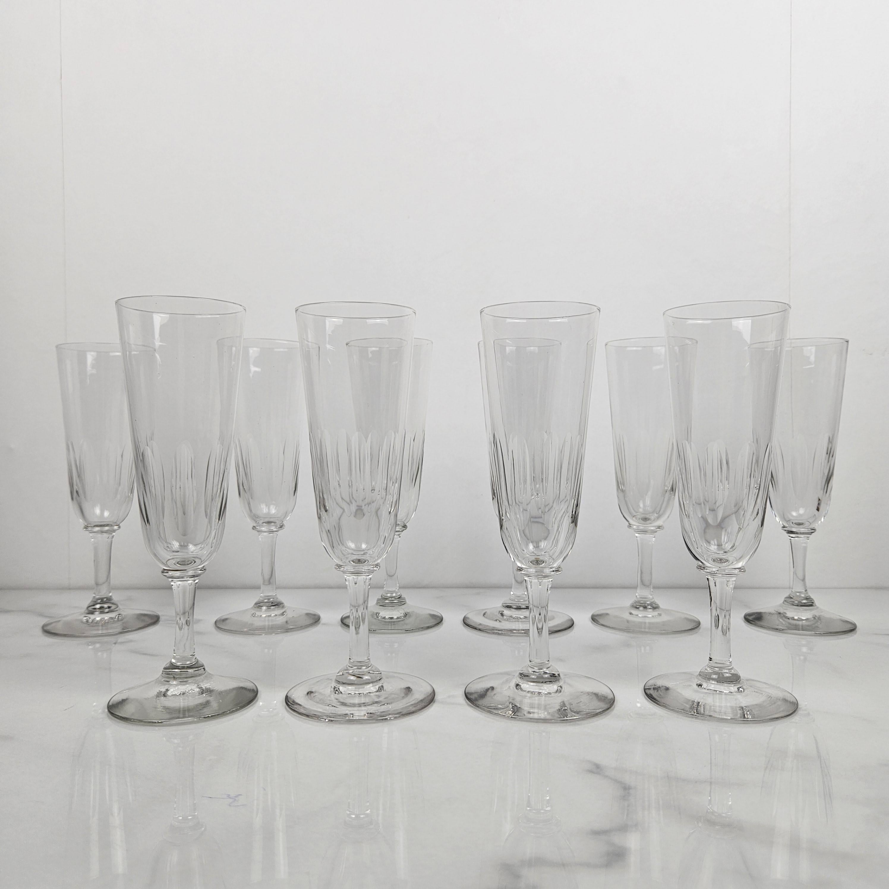 A refined set of ten antique French champagne glasses, crafted from clear glass circa 1880. 
Each flute features a beautifully cut lower bowl and a slender stem, offering both visual interest and a graceful silhouette. 
These glasses reflect the