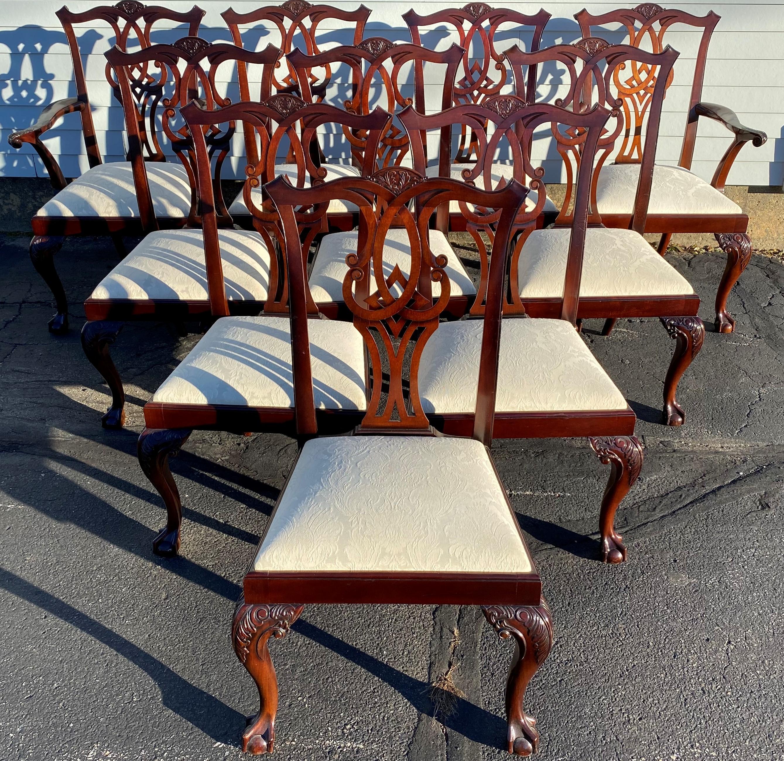A beautiful custom set of 10 mahogany Chippendale style dining chairs, including two armchairs and eight side chairs, with pierce carved crests and splats, beautifully carved cabriole front legs, terminating with ball and claw feet, and cream