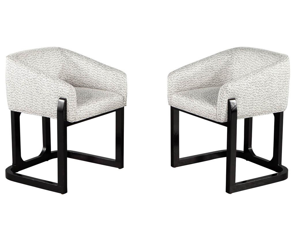 Set of 10 custom modern oak dining chairs in black and white. Unique modern design with solid oak base in a cerused black finish. Sleek angled arms with curved backs and exposed oak frame detailing. Completed in a rich textured fabric in black and