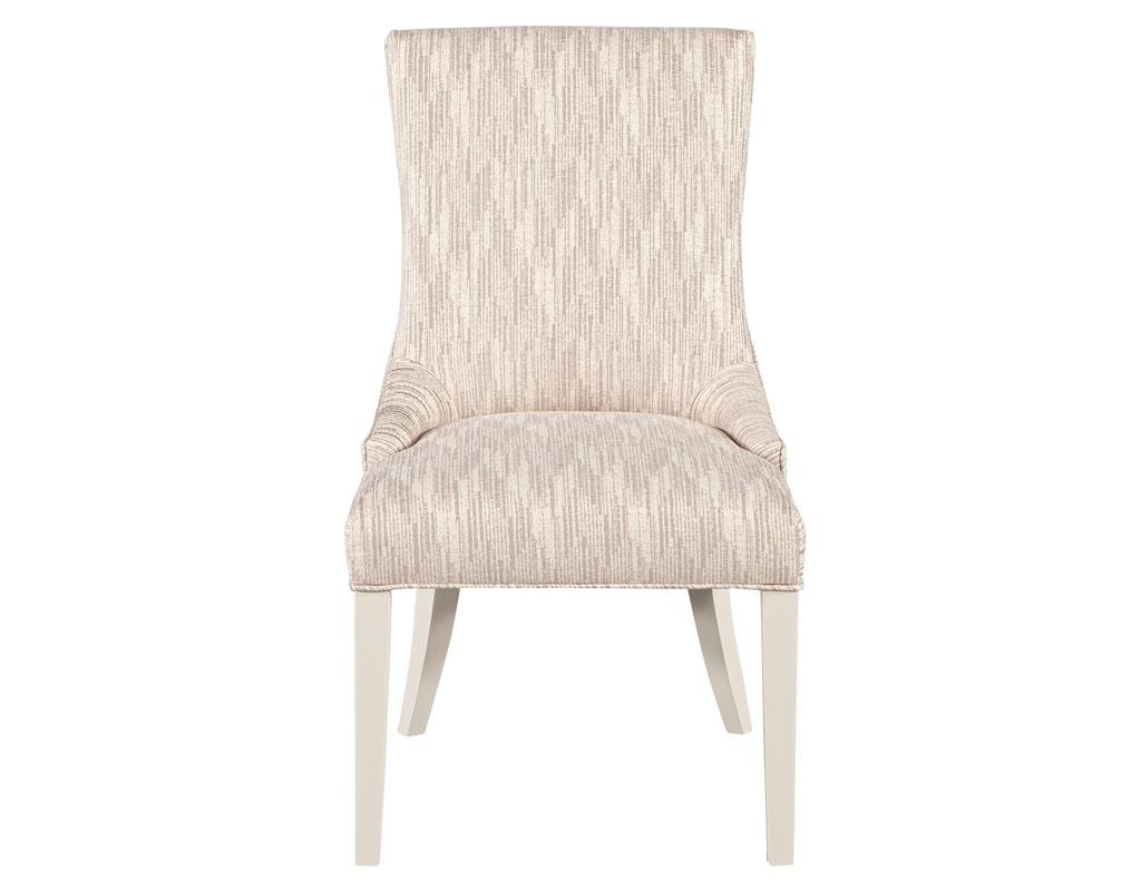 Set of 10 custom modern white lacquered dining chairs in designer fabric. The Carrocel Opus chair exudes comfort with its fully upholstered design. With generous seating space with curved wing backed design. Finished in a white lacquer with textured