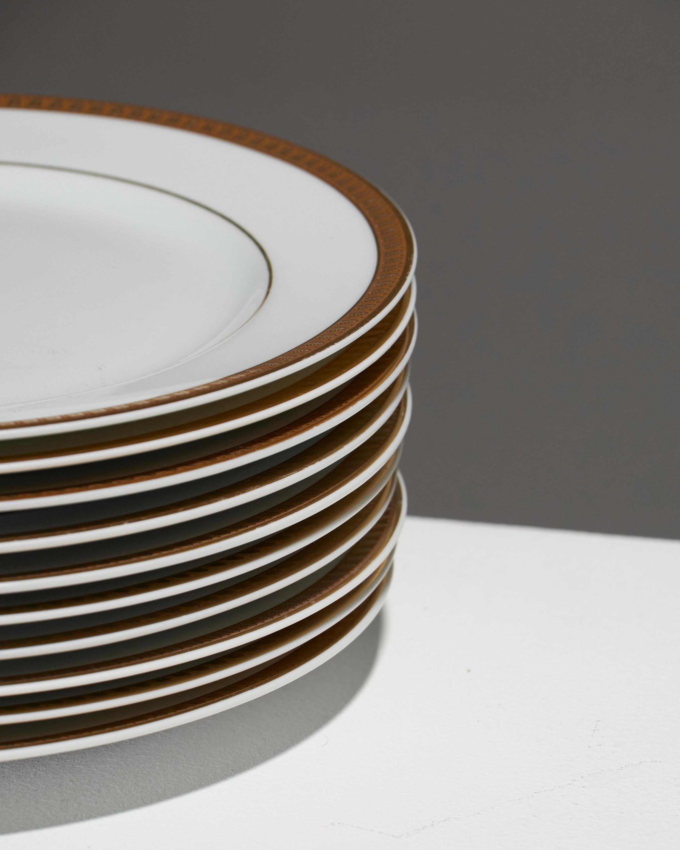 Ensemble de 10 assiettes à dessert en porcelaine fine, collection Malmaison de Christofle. Délicatement bordées d'un fin liseré d'or, elles allient élégance et intemporalité. Leur surface lisse et brillante met en valeur la pureté de la porcelaine,