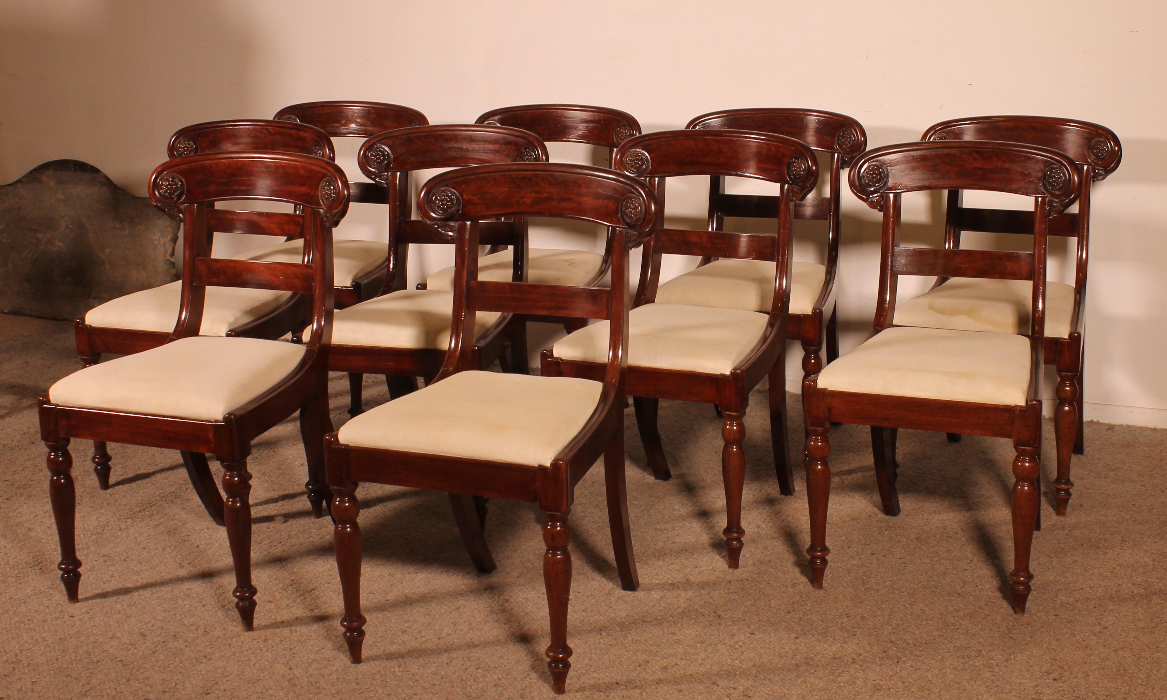Elegant ensemble de 10 chaises en acajou massif du début du 19ème siècle, 

Très bel ensemble de 10 chaises dont le dossier large les rend très confortables. La bande est décorée de deux fleurs.
Elles reposent sur une très élégante base