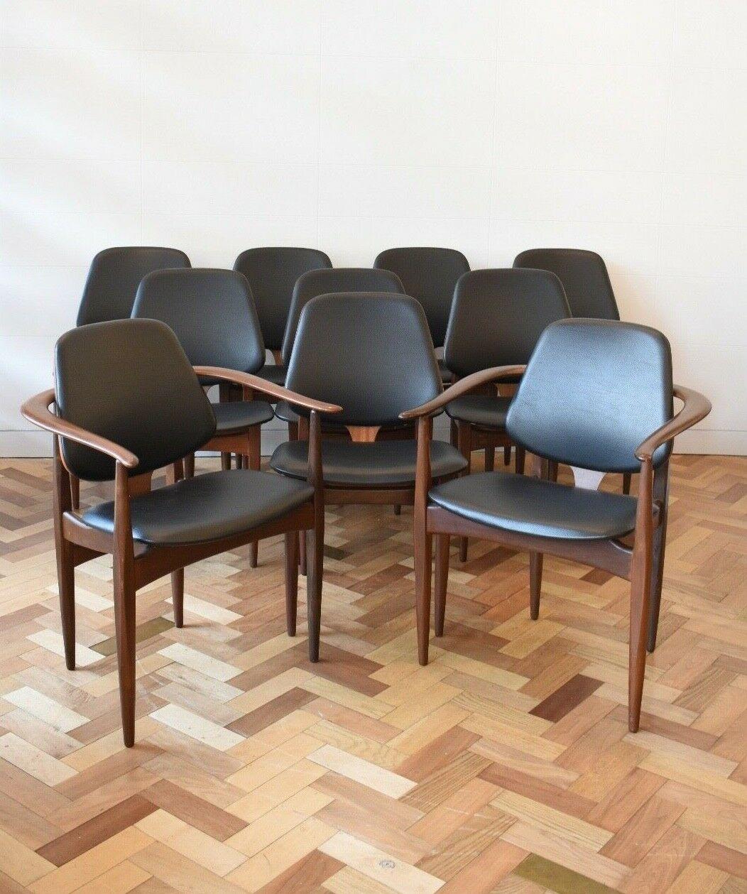 Set of ten gorgeous dining chairs made by English maker Elliots of Newbury in the 1960s. These elegant teak chairs feature a sculpted back with recently upholstered black vinyl cushions whilst the sets rarity is increased greatly by the two