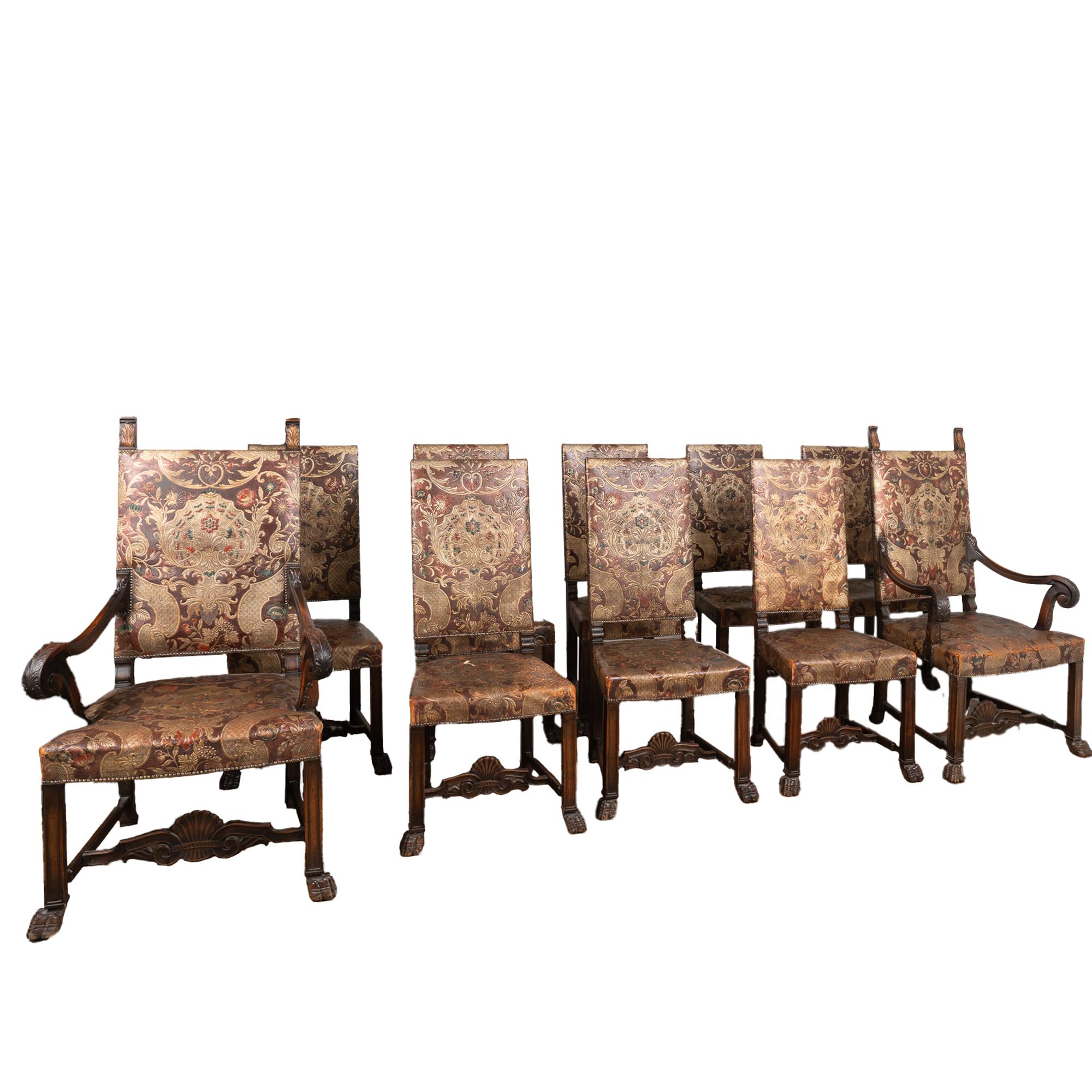 Dramatic set of 10 embossed and hand-painted leather dining chairs with carved oak feet and stretchers. Set includes 8 side chairs and 2 arm chairs. 
Elaborate details abound in each chair, with intricate embossed patterns and flourishes in the