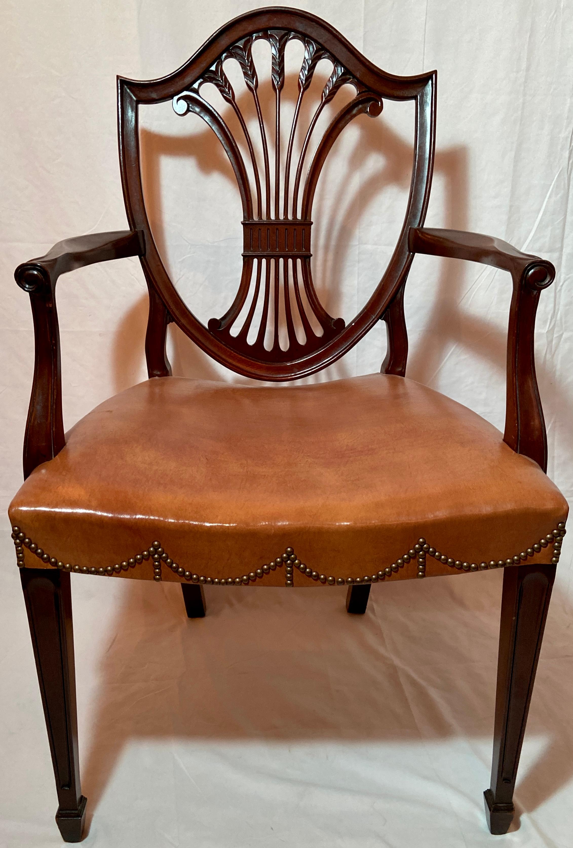 Set of 10 Estate English mahogany Hepplewhite shield-back dining chairs, circa 1940s-1950s. Leather upholstery with pretty grommet detailing.
8 side chairs and 2 armchairs.