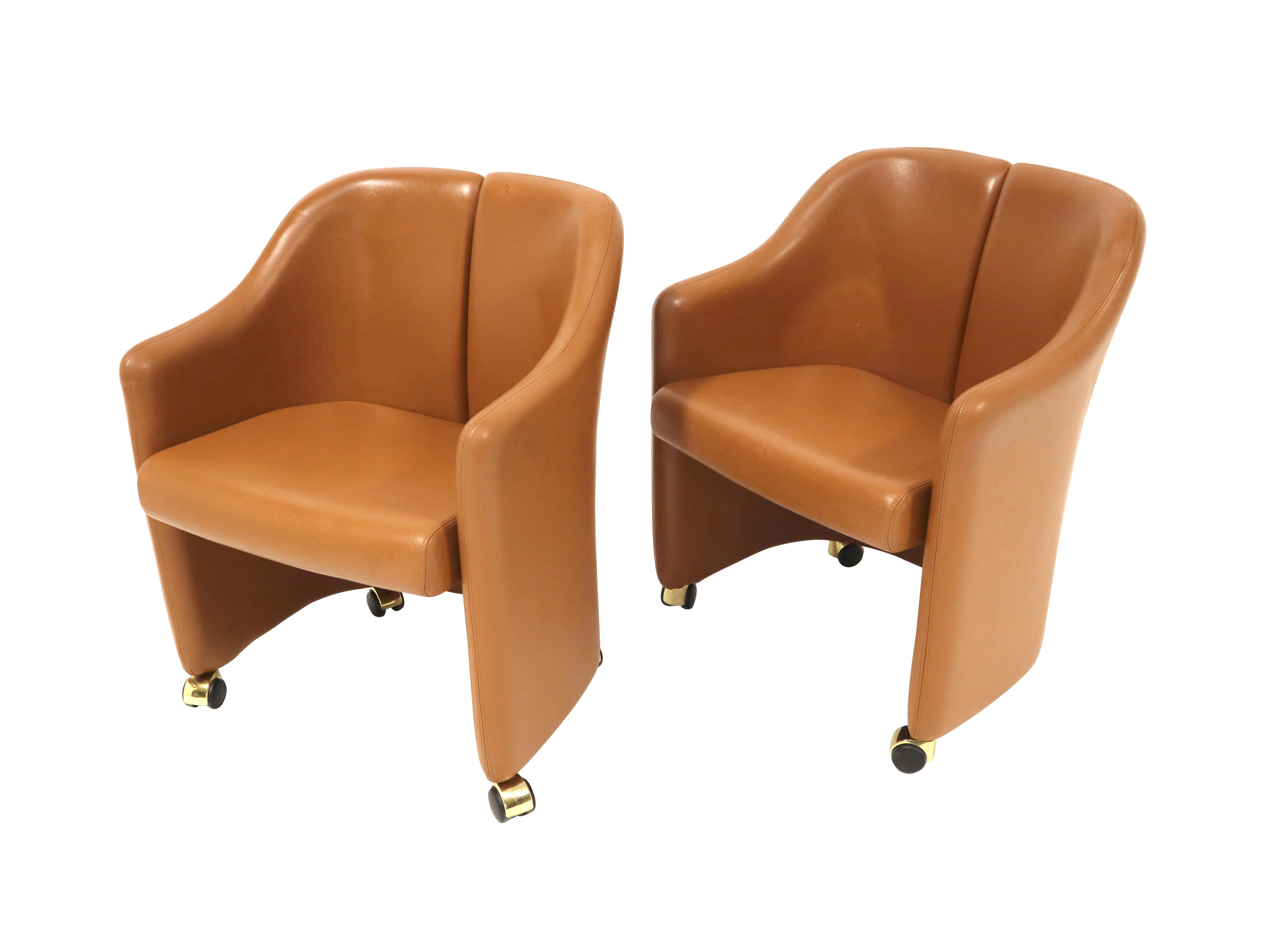 Set of 10 Eugenio Gerli for Tecno leather dining chairs.  These are the taller “Series 142- Executive model”, which are the more rare dining height chairs from this line.  Original camel color leather is in excellent condition. Brass caped wheels
