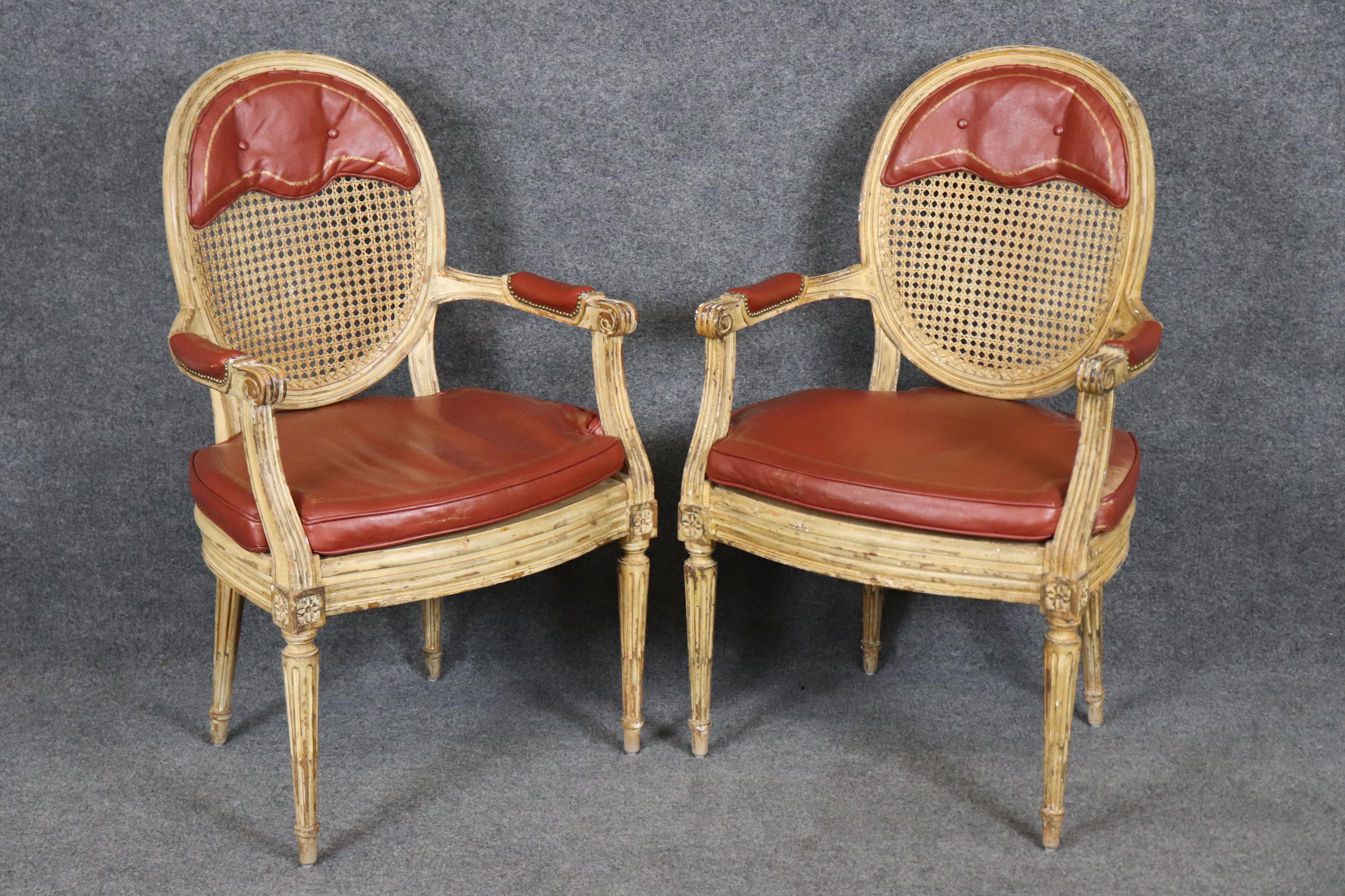 Cet élégant ensemble de 10 chaises de salle à manger de style Louis XVI français des années 1950 présente des cadres en bois sculptés à la main, des dossiers classiques en cannage et un revêtement en cuir d'origine, ce qui donne une touche
