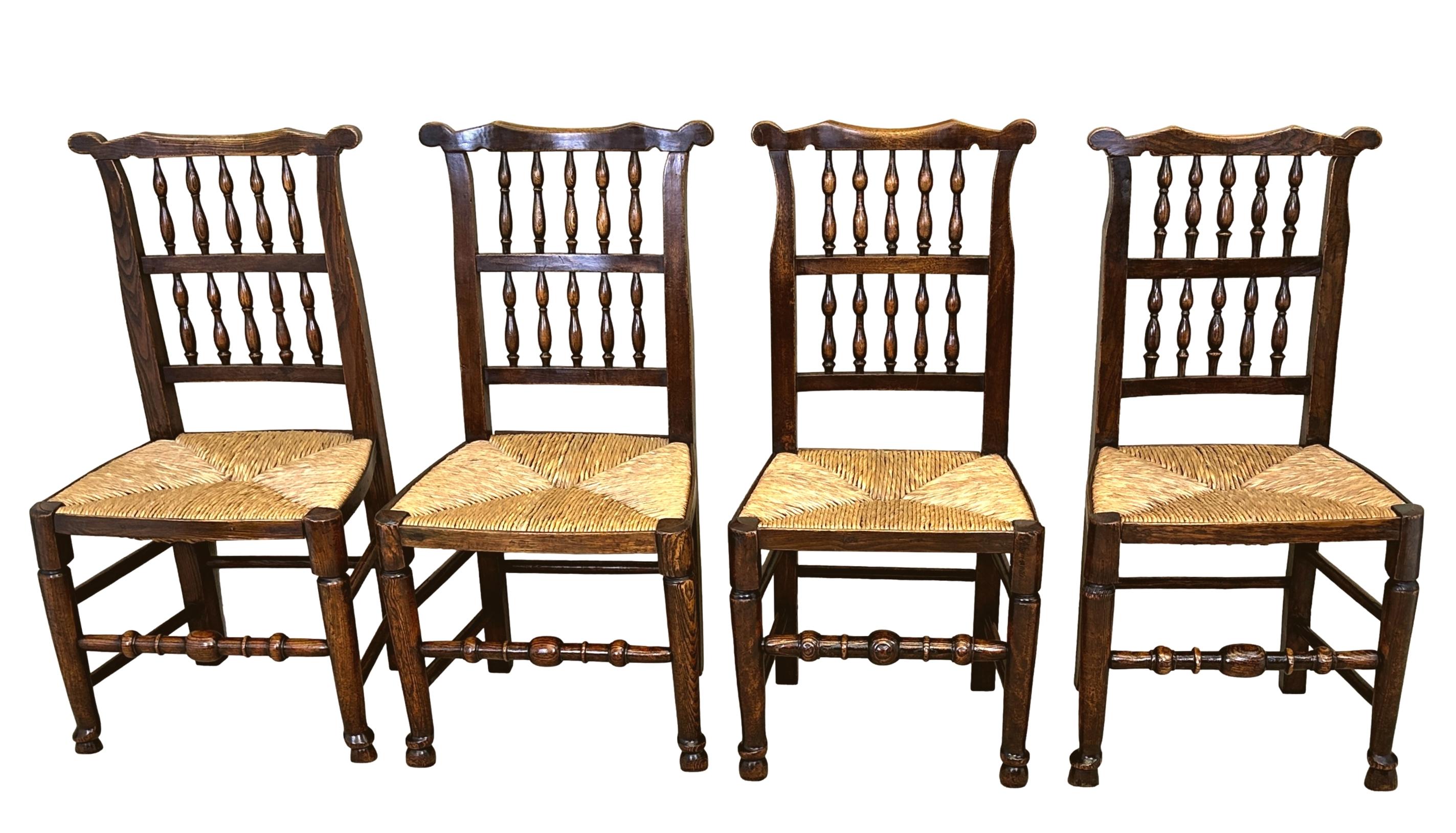 Atractivo conjunto georgiano de principios del siglo XIX de 10 sillas de comedor de cocina de granja de fresno y olmo, con orejas raras en el riel superior de los respaldos de huso de doble hilera, sobre asientos enrasados elevados sobre elegantes