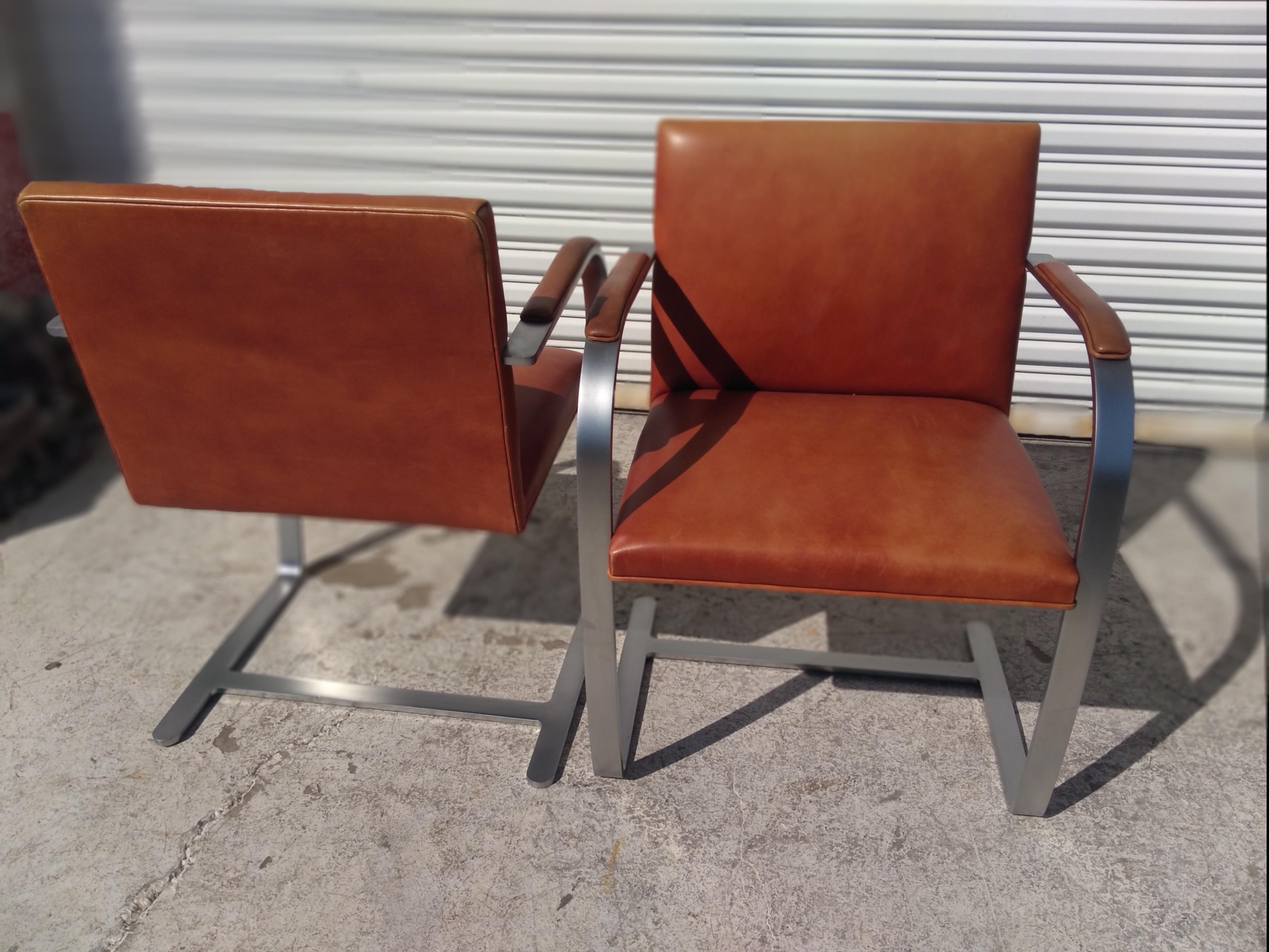 These are vintage Brno armchairs designed by Mies van der Rohe for Knoll Furniture. These chairs have a beautiful brushed chrome and a wonderful patina to the leather. The arms are padded and also have a distressed leather look. There are 20 chairs