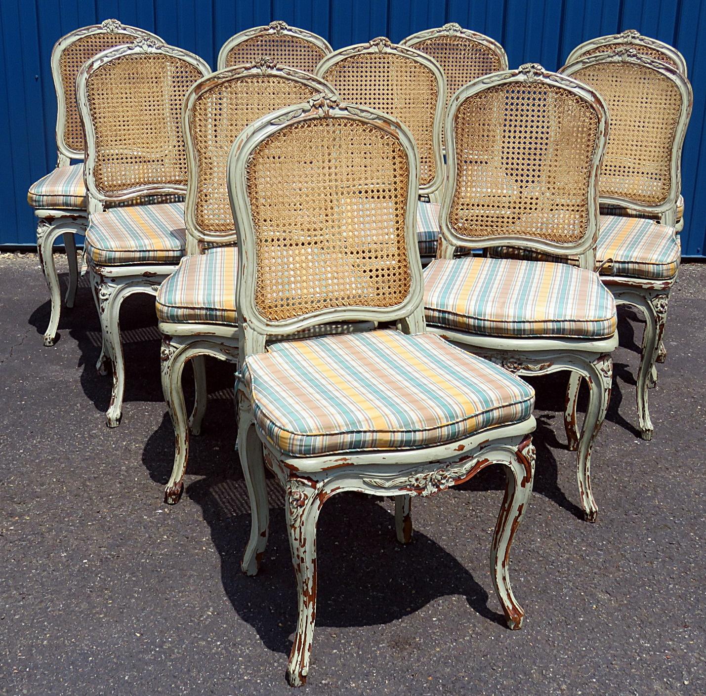 Set of 10 Louis XV style distressed painted dining side chairs with removable cushions and caned seats and backs.
