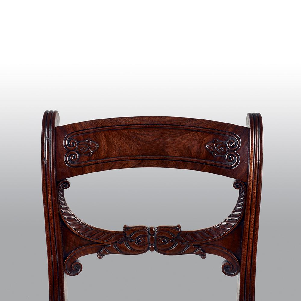 An important set of 10 mahogany Regency period dining chairs, including two carvers, with Grecian key moldings and saber legs. In the manner of George Smith.