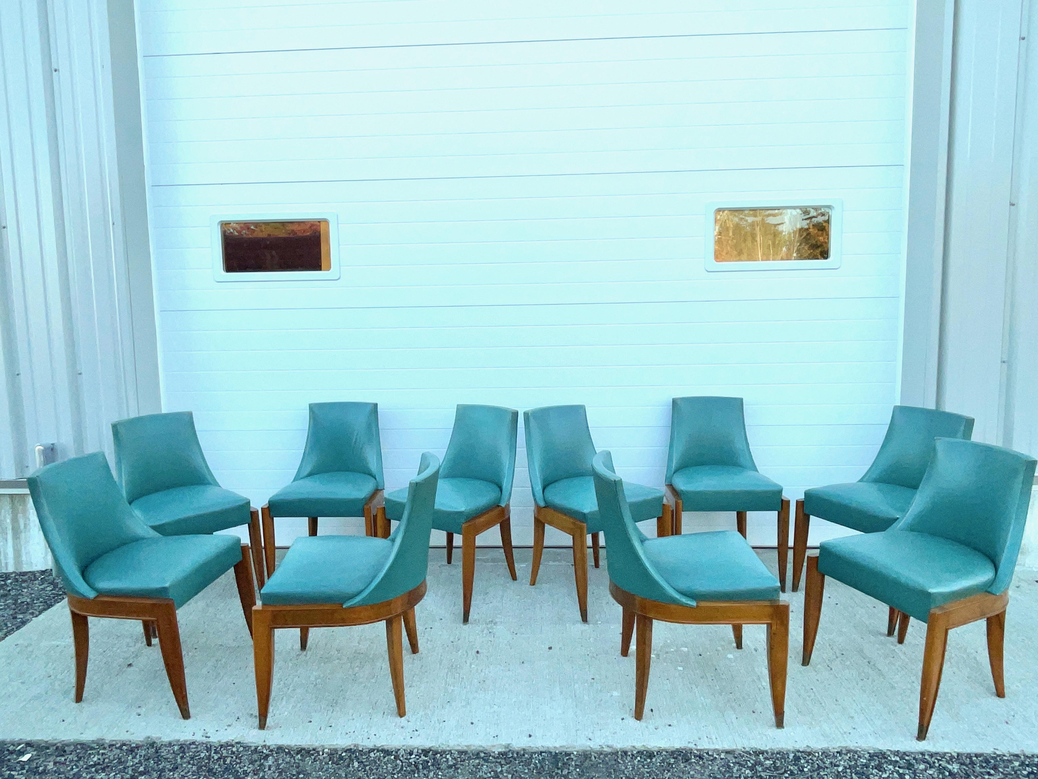 Set of ten French art deco gondola dining chairs by Maurice Jallot circa 1939.
Mahogany and blue/green leather.
Incised saber legs ending in brass sabots.
Published in Mobilier et Décoration 1939 Fevrier.

Provenance: Collection of Guy and