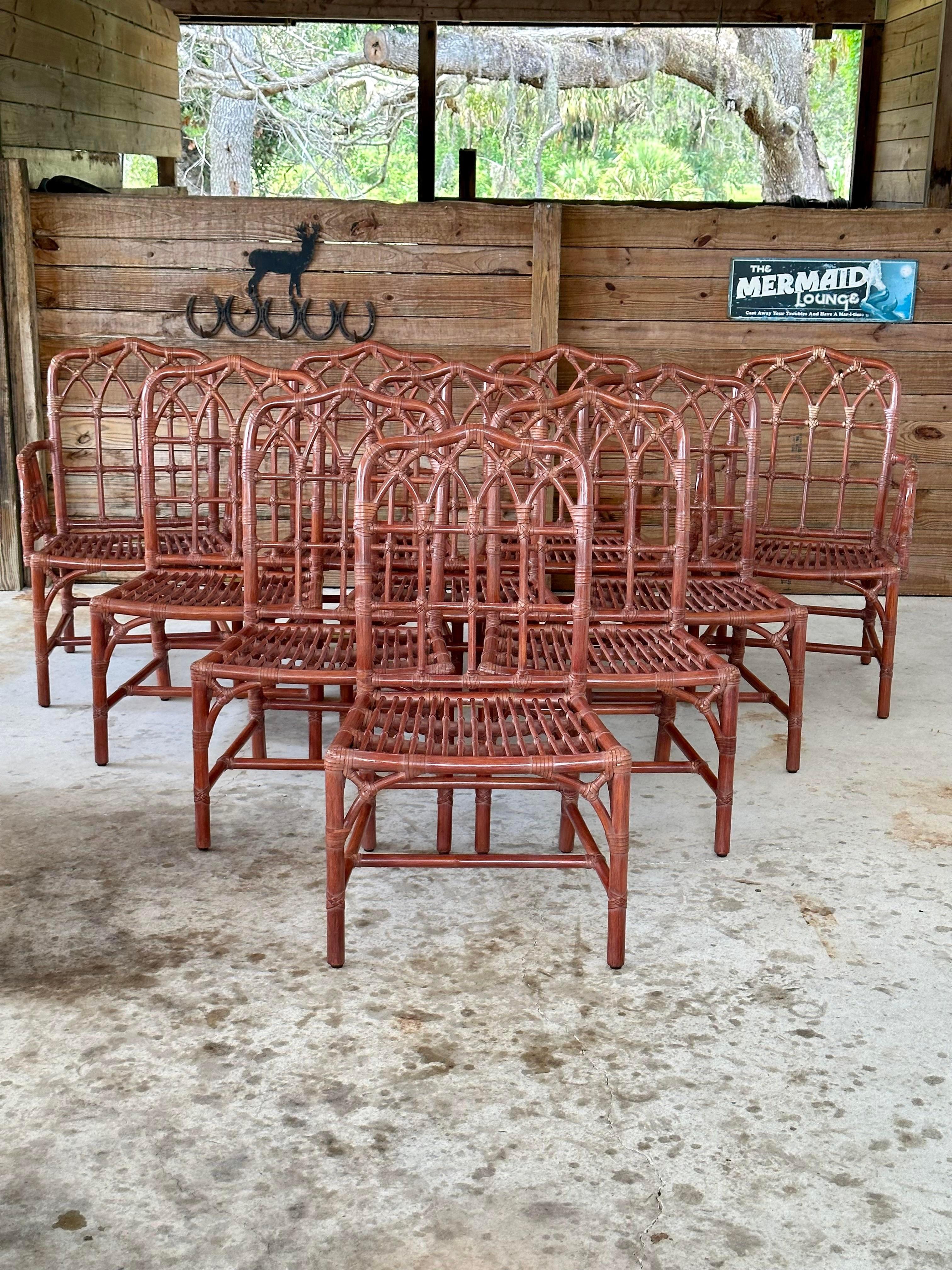 Introducing an exquisite one-owner set of 10 McGuire rattan dining chairs in the original Rose finish. This rare collection features eight side chairs and two armchairs, each adorned with rawhide laces and previously upholstered cushions. Every