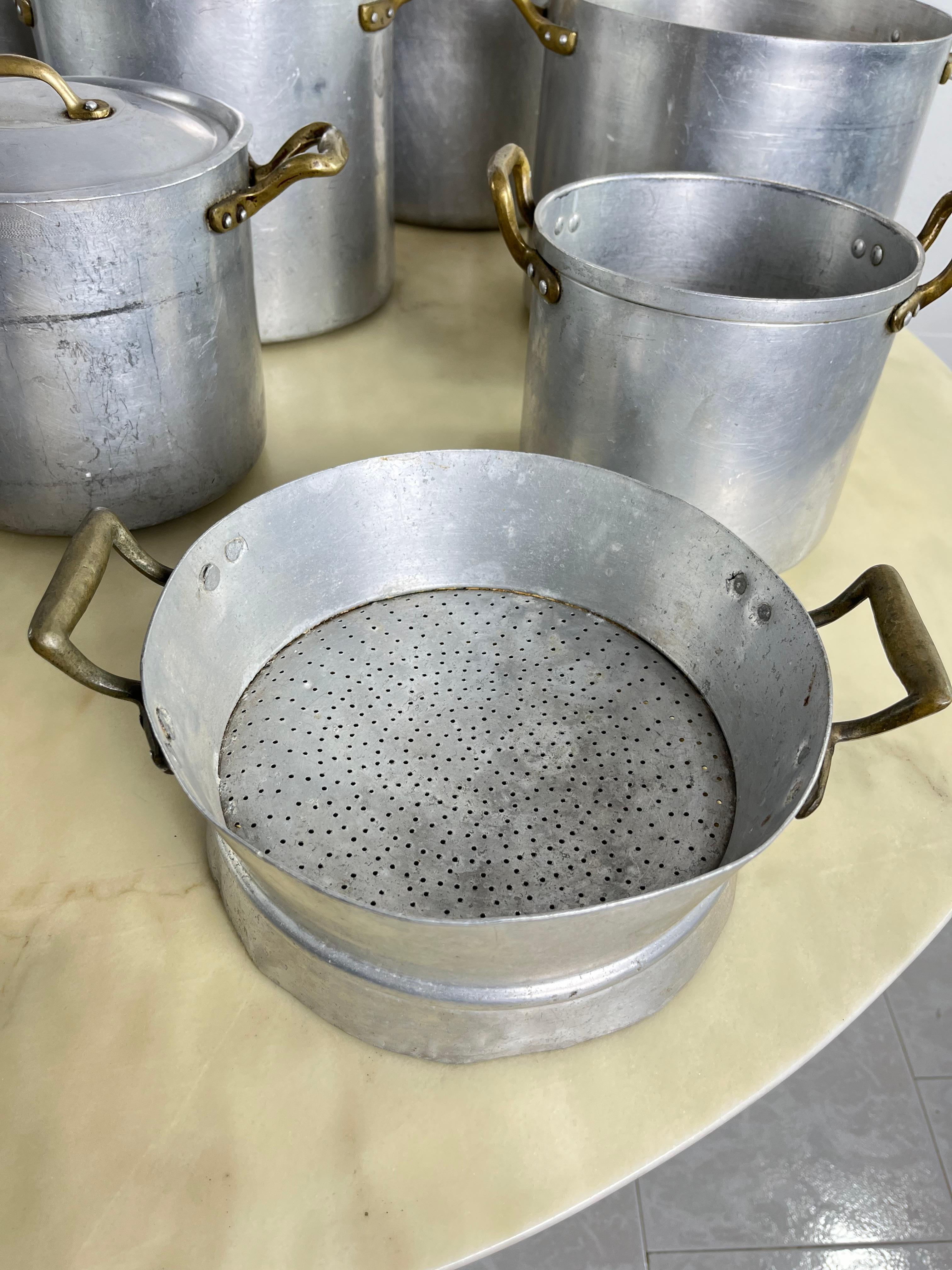 Ensemble de 10 casseroles, poêles et tamis en aluminium et laiton du milieu du siècle 1940 
Les grands pots ont un diamètre de 27 cm.
Bon état, signes de vieillissement.