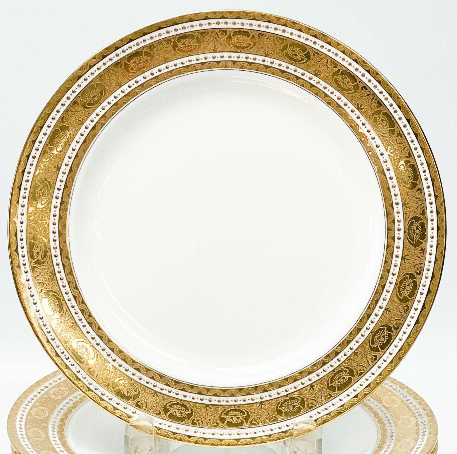 Set of 10 Minton England Gilt Porcelain 9 inch plates in H1417, 1910

A white ground to the center, ornate gilt decoration to the edge featuring florals and twisted ribbons. Bands of raised gilt dot decoration. Underside with Minton