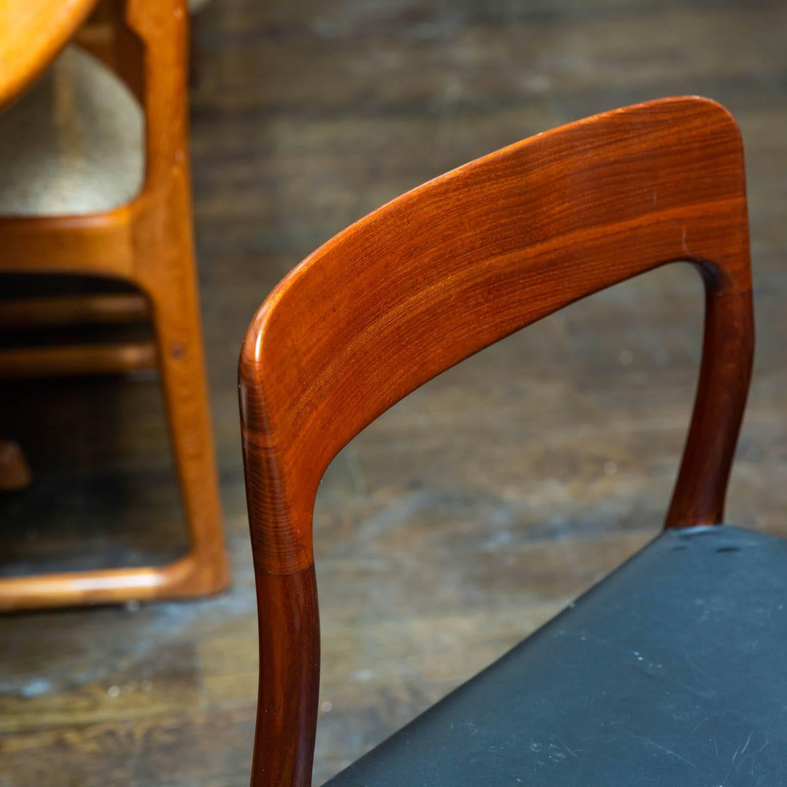 Newly recovered in black naugahyde, this is a rare set of solid teak chairs that has been together in one family since the sixties.