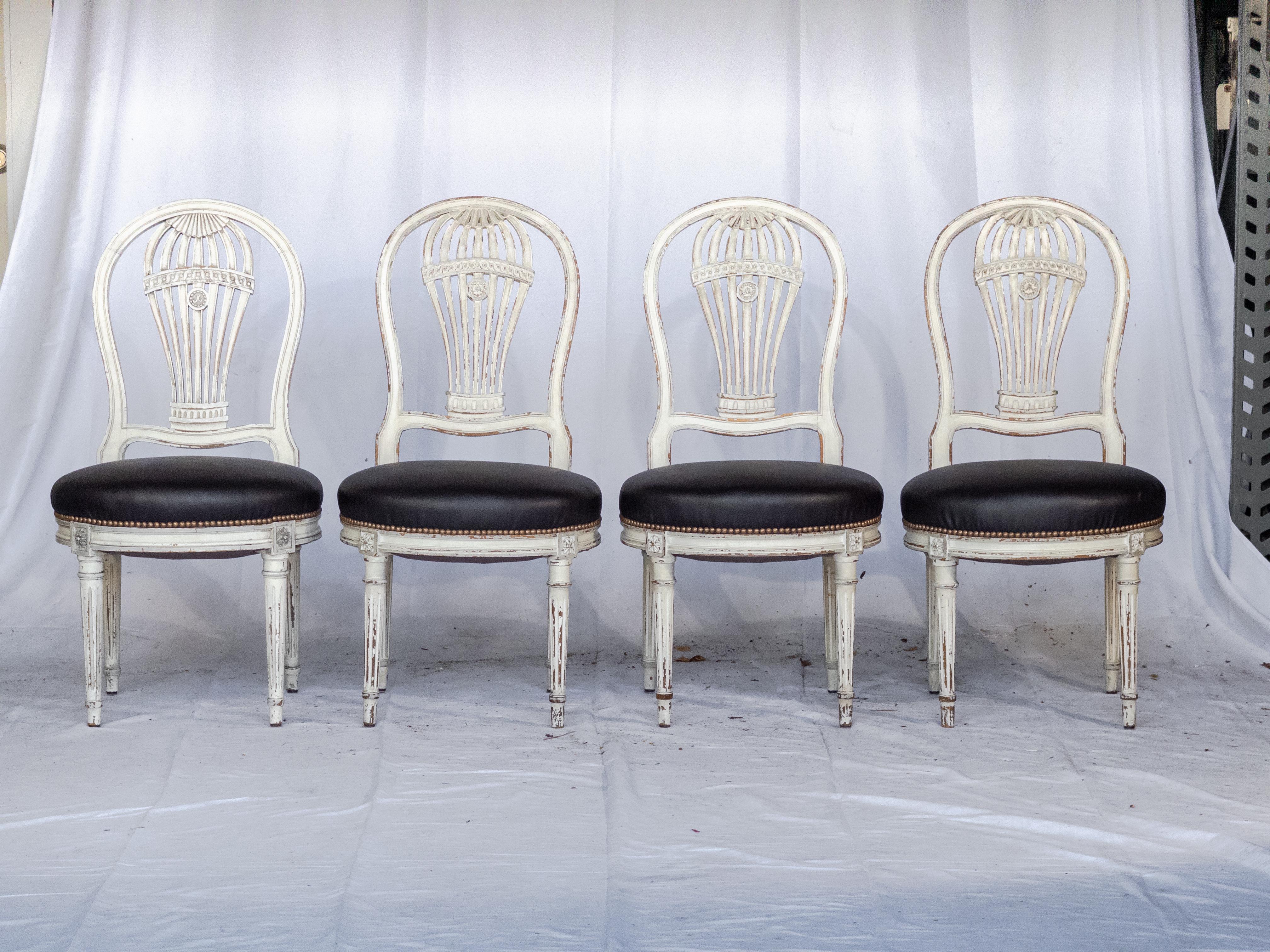 Embarquez pour un voyage dans le temps avec cet ensemble de 10 chaises de salle à manger Montgolfier du 20e siècle de style Louis XVI peint en blanc et à dossier de montgolfière, resplendissantes dans leur élégance intemporelle et leur état